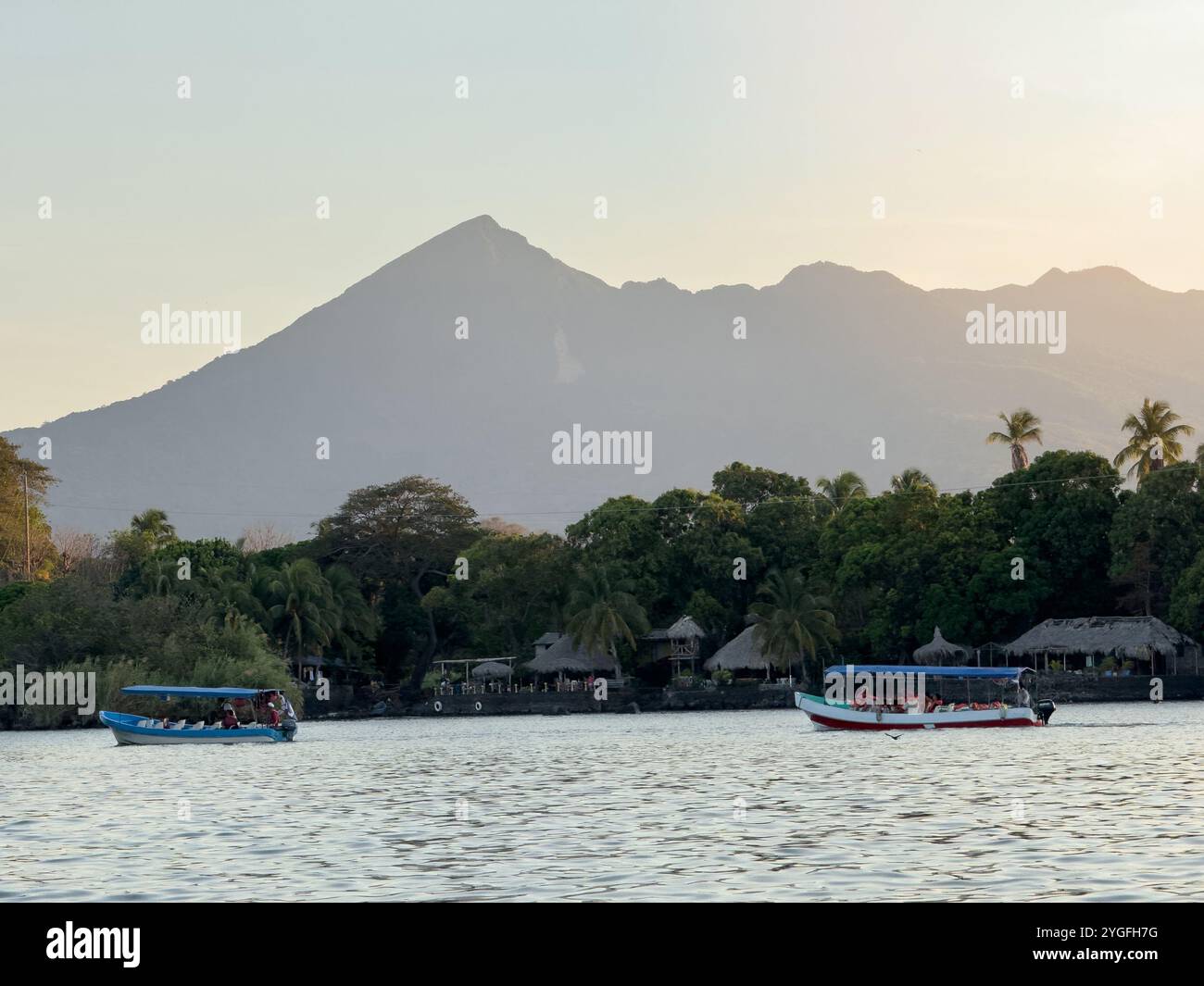 Boote auf Tour, um die tropische Landschaft mit Vulkan zu sehen Stockfoto Boote auf Tour, um die tropische Landschaft mit Vulkan zu sehen Stockfoto
