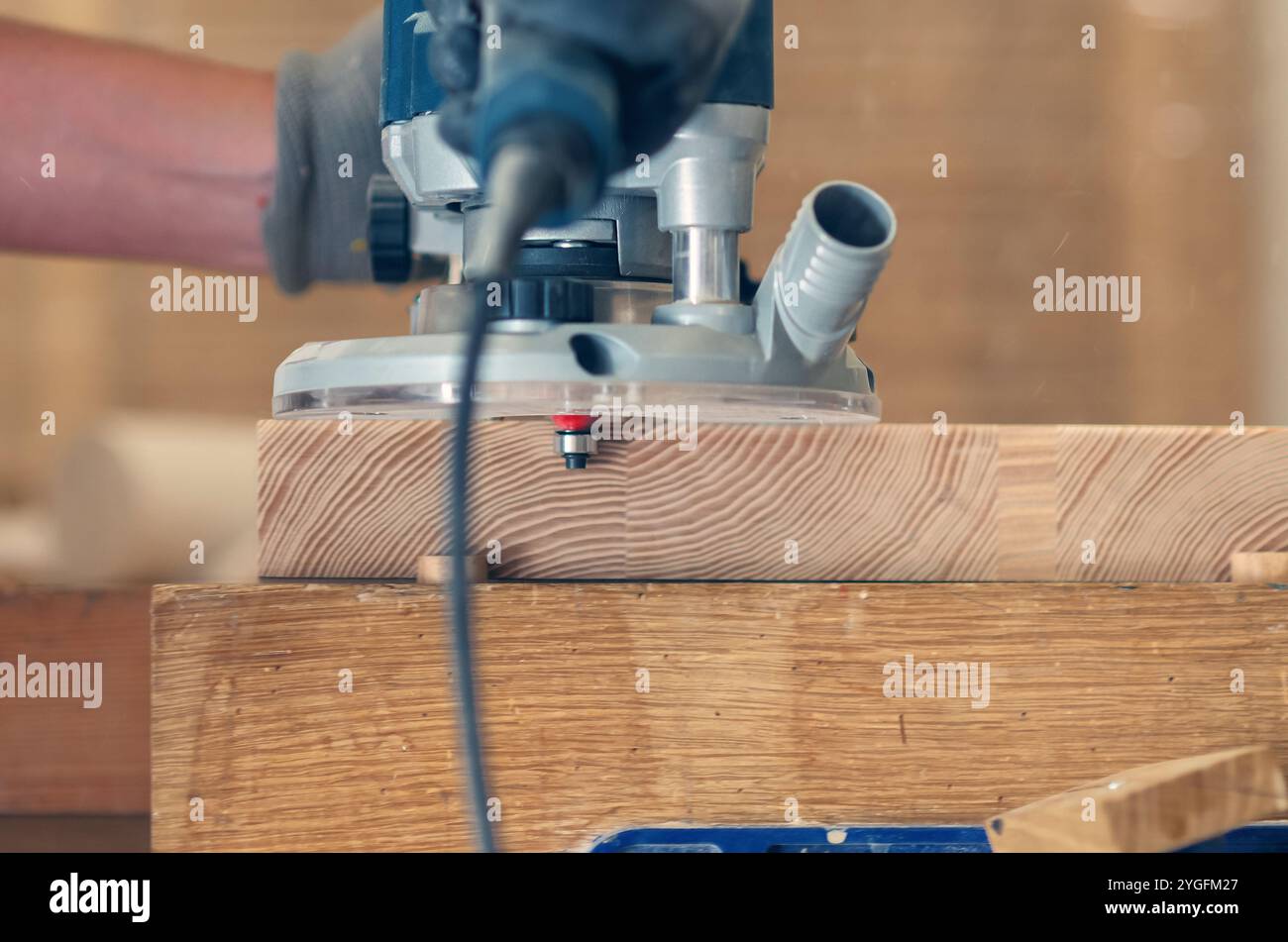 Glätten der Kanten eines Holzbretts mit einem Handfräser, Nahaufnahme der feinen Handwerkskunst Stockfoto