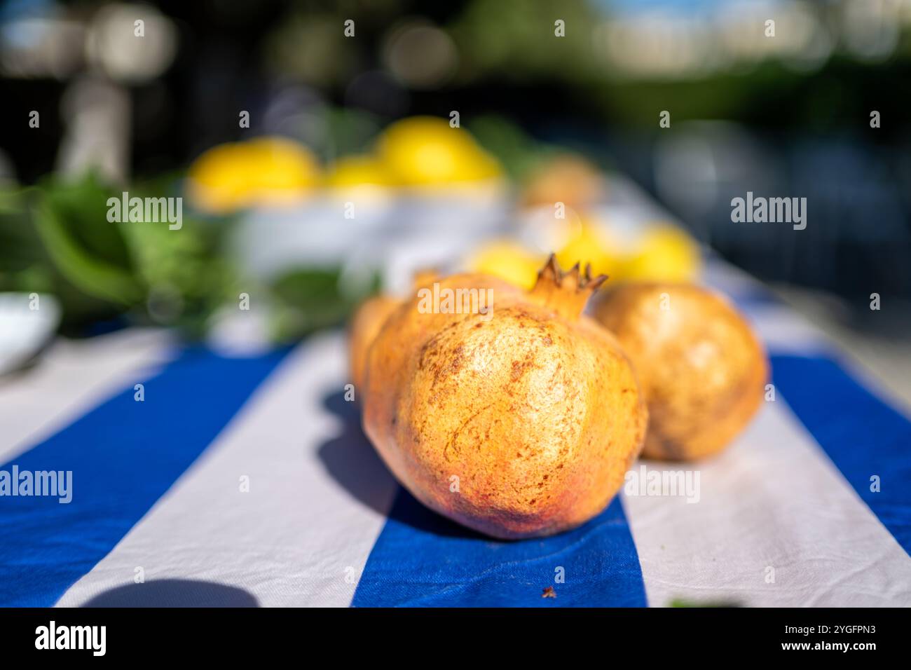 Ein Nahbild eines Tisches mit Granatäpfeln und Zitronen, der bei einer lebhaften Hochzeitsfeier im Freien in Malaga, Spanien, aufgestellt wird. Fängt die Frische ein und f Stockfoto