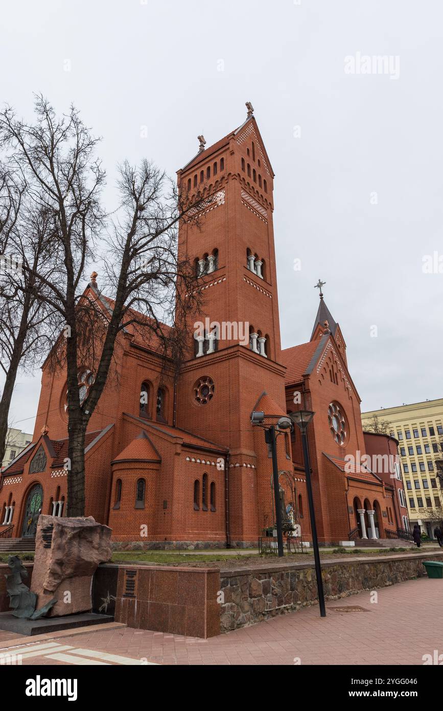 Minsk, Weißrussland - 3. Januar 2024: Touristen sind an einem bewölkten Wintertag vor der Kirche der Heiligen Simon und Helena, vertikales Foto Stockfoto