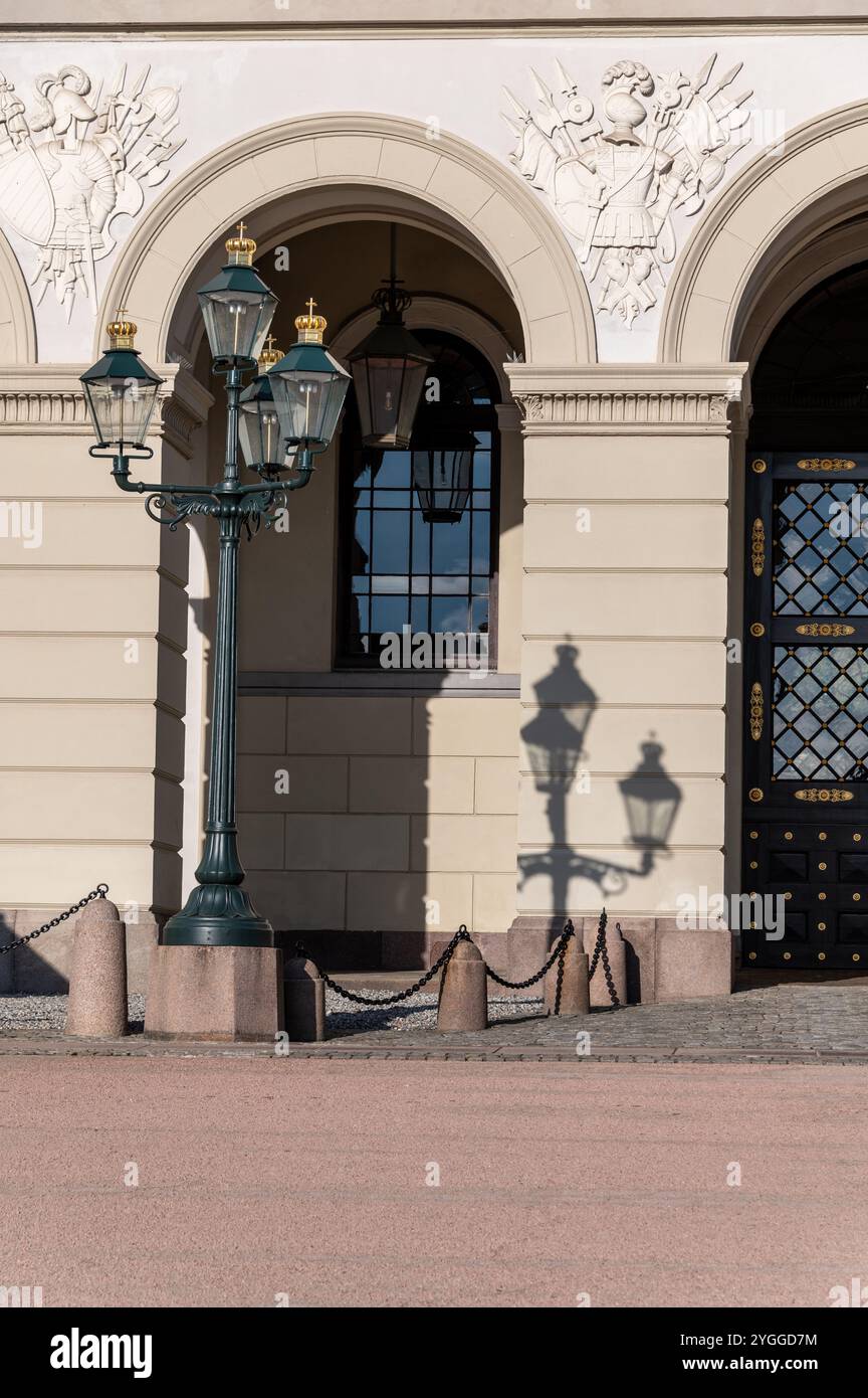 Ein alter Straßenlaternenpfosten wirft seinen Schatten auf die Wand des Königspalastes, der offiziellen Residenz des gegenwärtigen norwegischen Monarchen, ihrer Ma Stockfoto