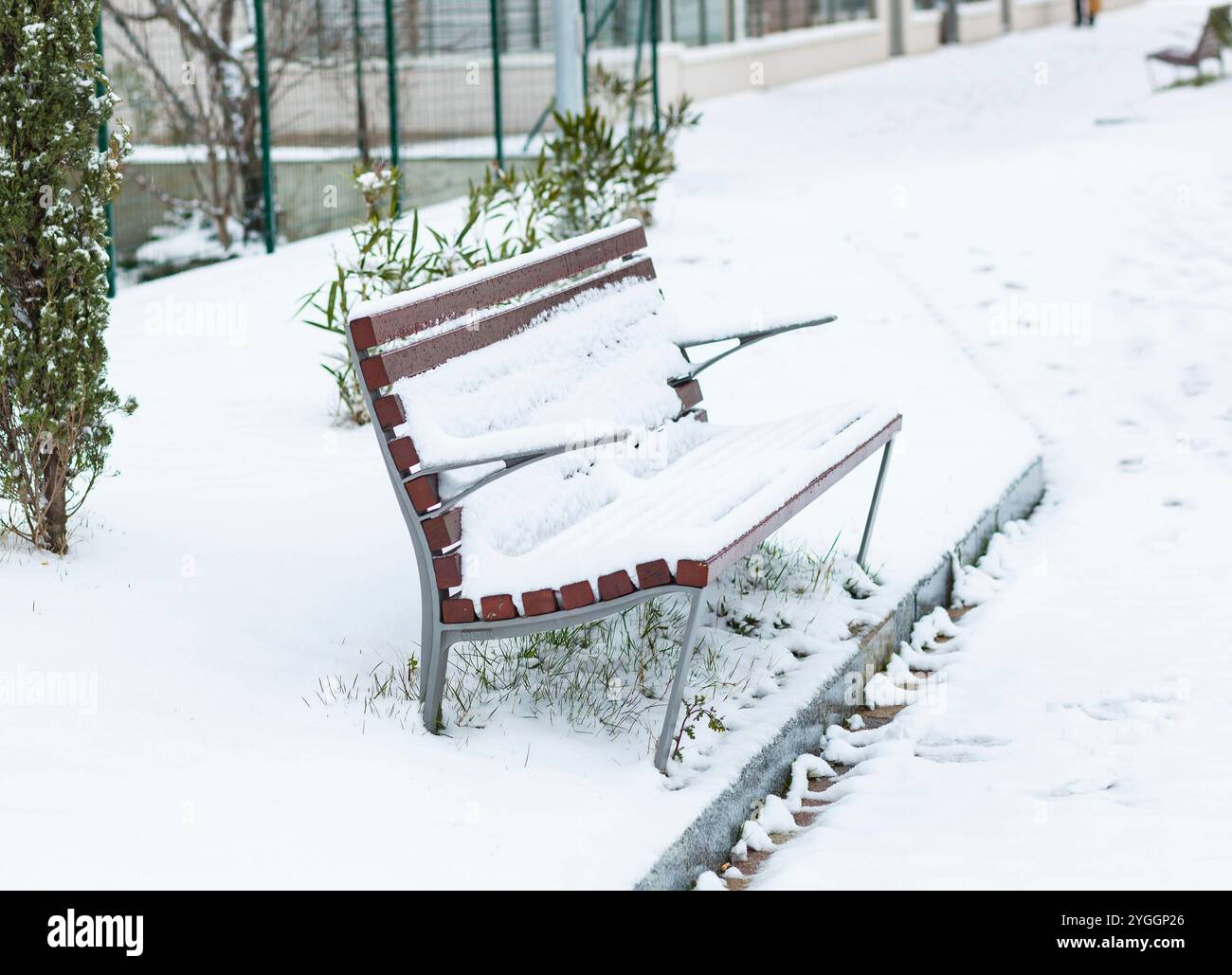 Bank bedeckt mit Schnee im Park am März Tag. Stockfoto