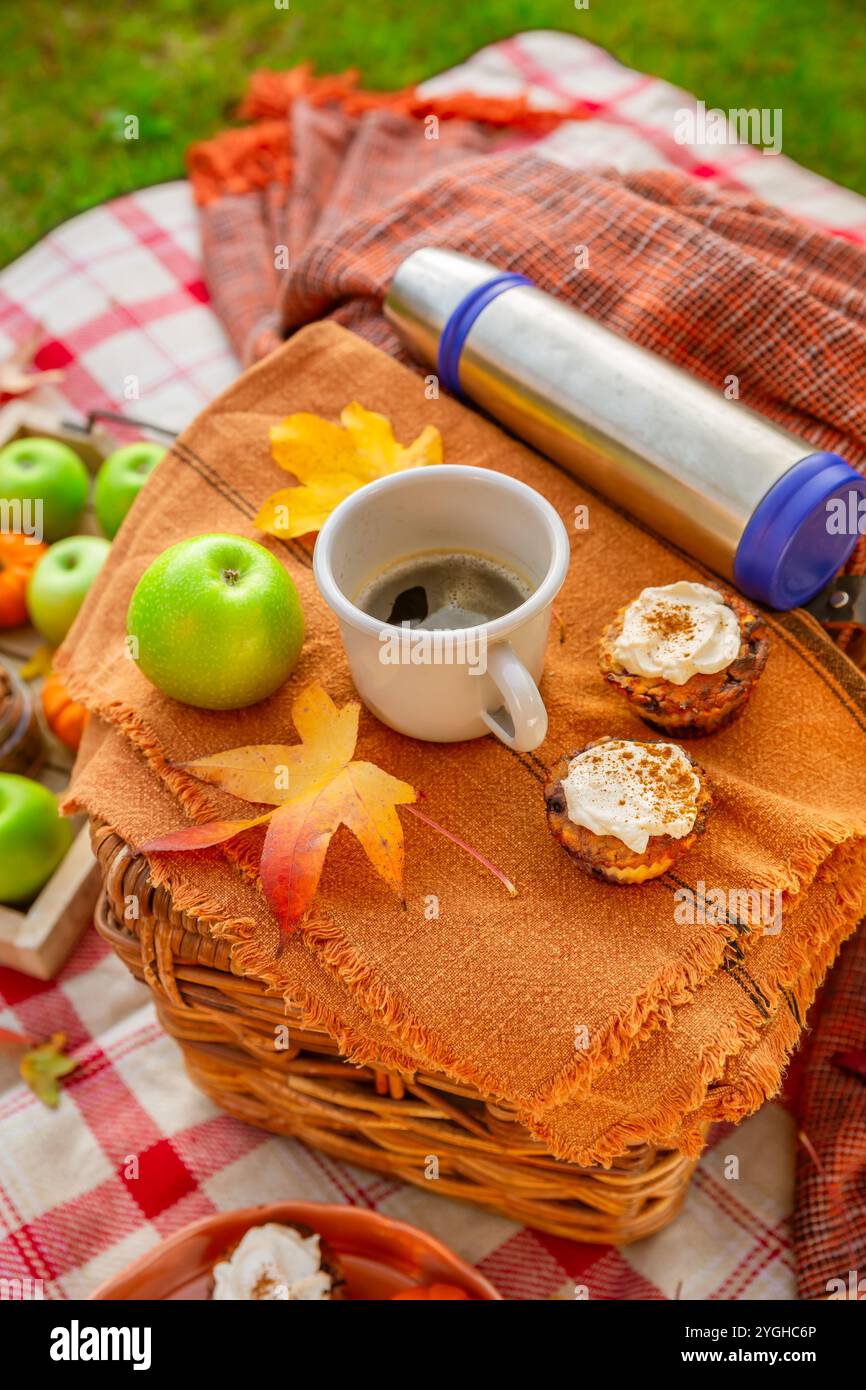 Herbstpicknick in einem Park mit Kürbis-Cupcakes und Muffins, Kaffee und Tee Stockfoto