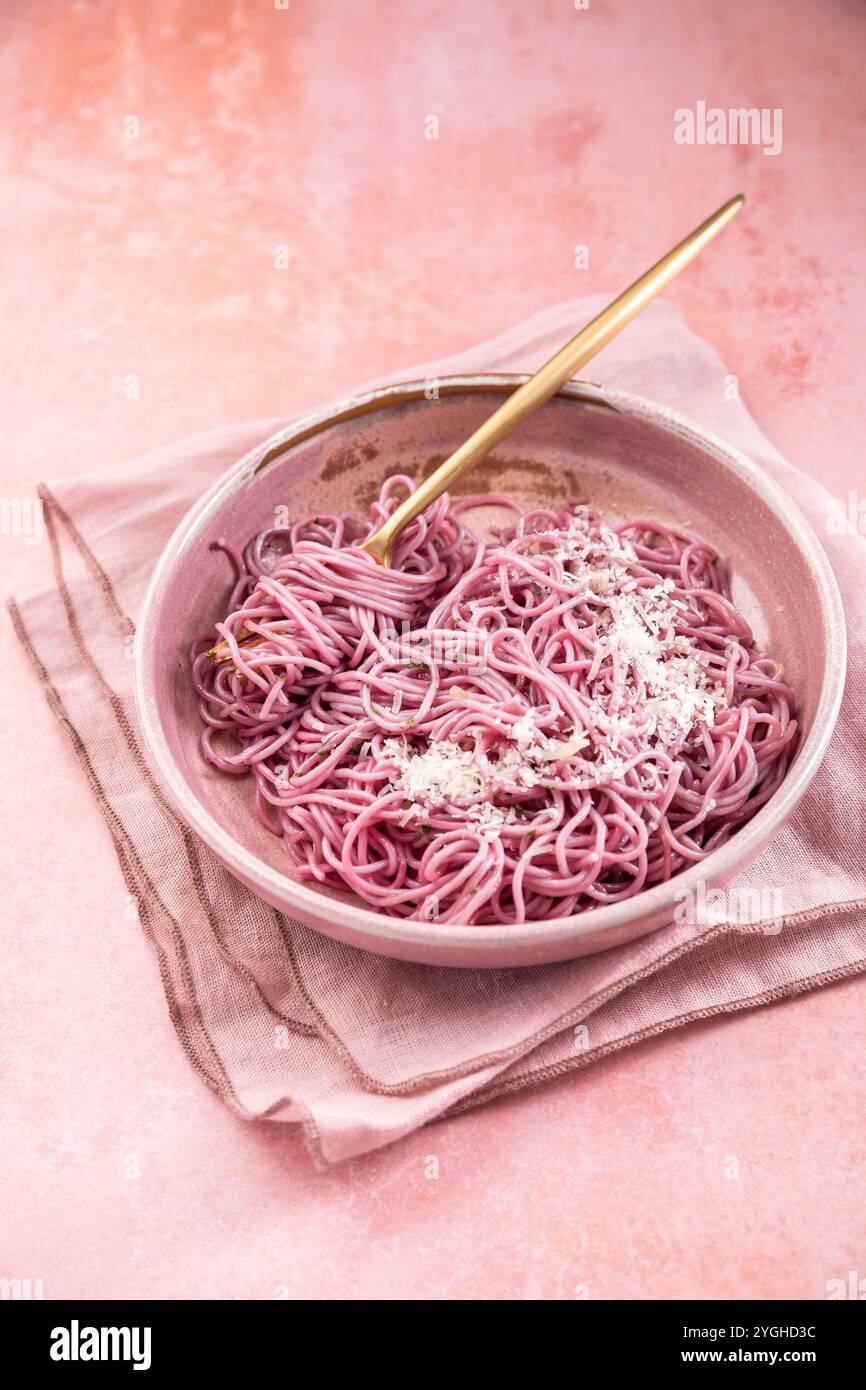 Hausgemachte rosa Nudeln mit Knoblauch, Zitrone und Parmesan, natürlich gefärbt durch Rotkohl Stockfoto