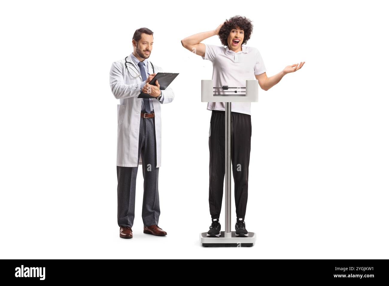 Junger Mann bei einer medizinischen Untersuchung, der auf einer Waage steht, isoliert auf weißem Hintergrund Stockfoto