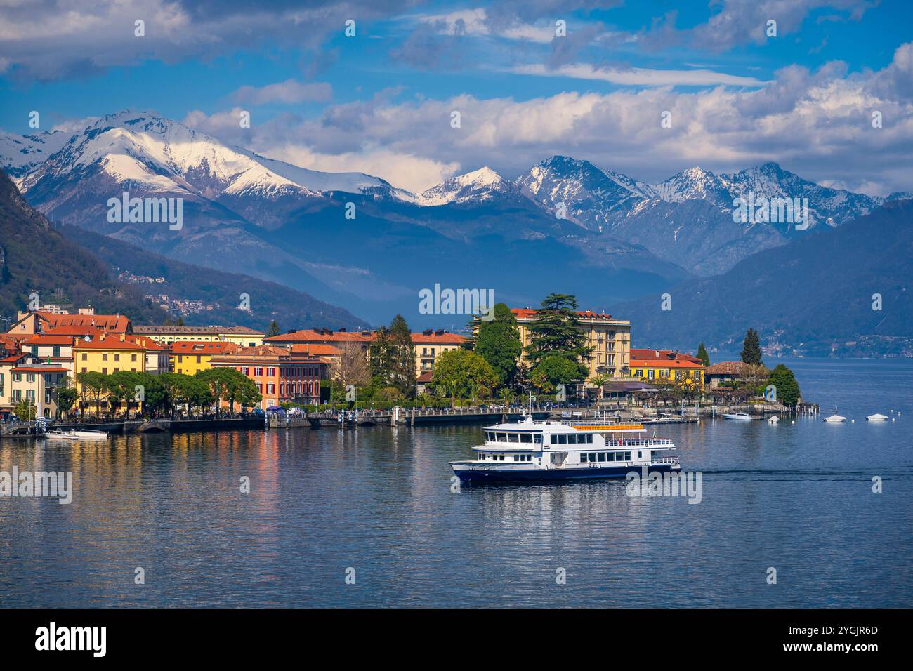 Fähre in Menaggio am Comer See, Italien mit schneebedeckten Bergen im Hintergrund Stockfoto