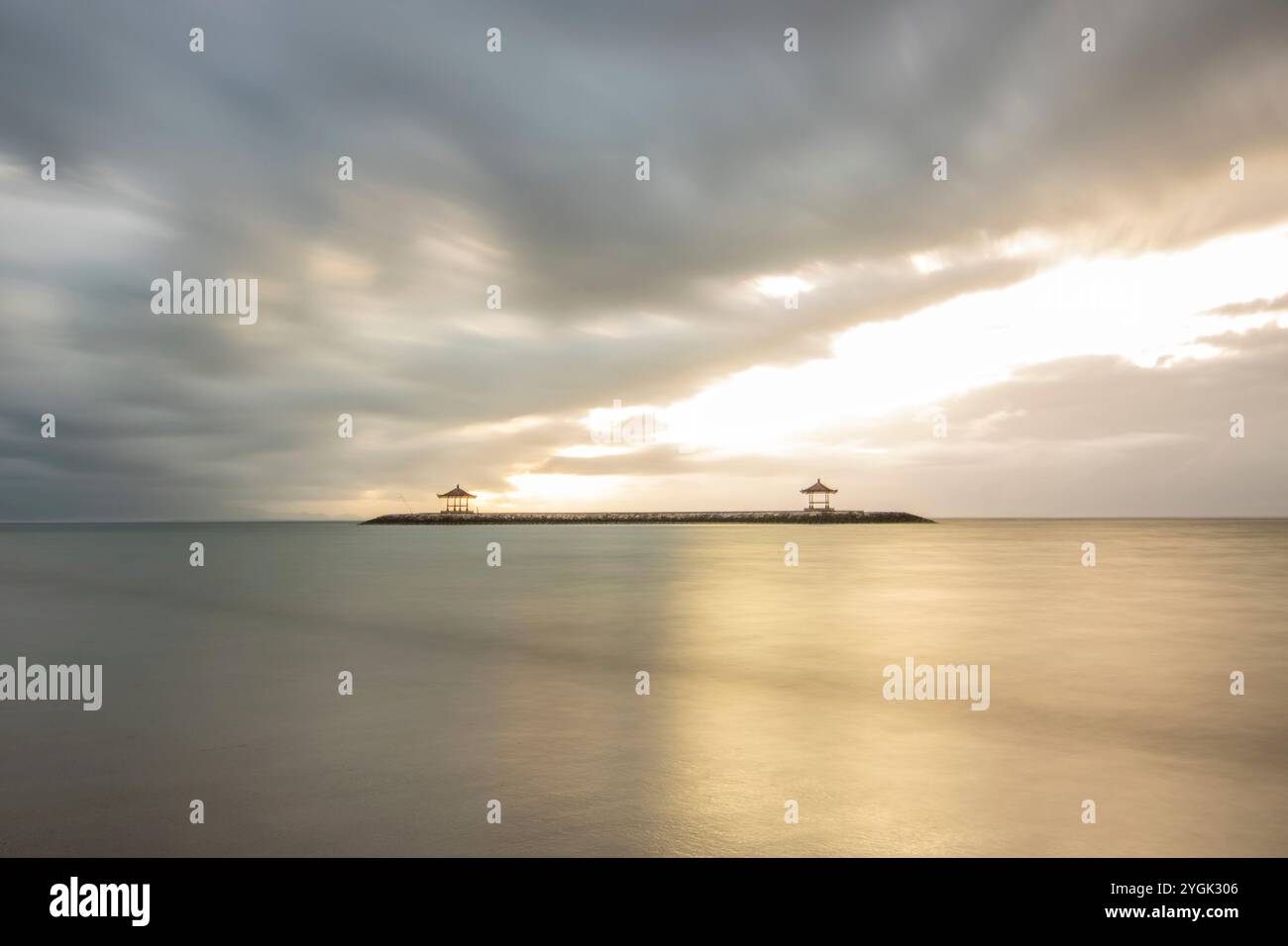 Fantastischer Sonnenaufgang am Strand mit kleinen Tempeln. Blick auf das Meer bis zum Horizont. Sanur, Bali, Indonesien Stockfoto