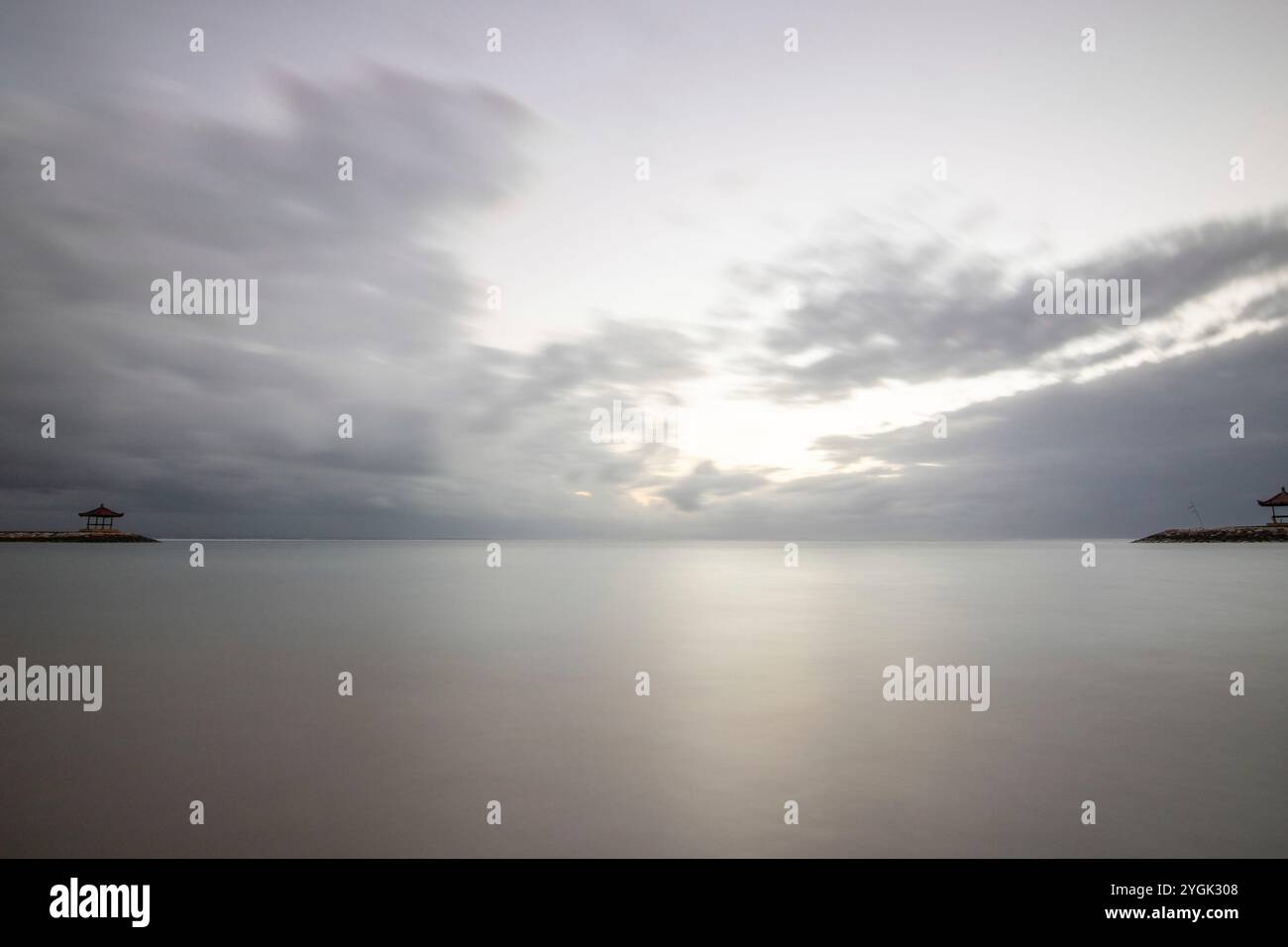 Fantastischer Sonnenaufgang am Strand mit kleinen Tempeln. Blick auf das Meer bis zum Horizont. Sanur, Bali, Indonesien Stockfoto