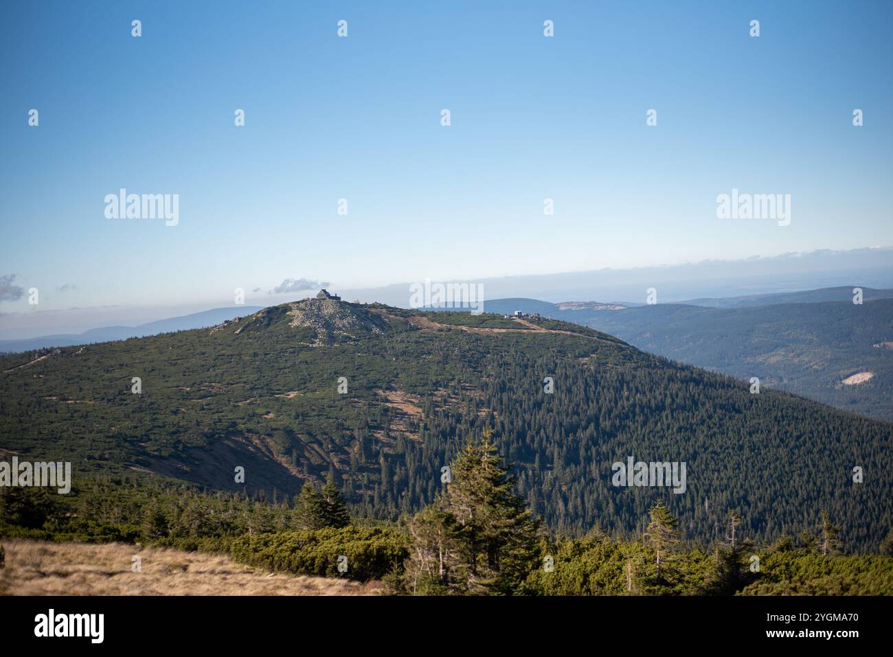 Die herbstliche Landschaft in den Bergen von Szklarska Poręba, Polen, besticht durch lebhaftes Laub, nebelige Gipfel und friedliche Wanderwege, umgeben von Gold und Rot Stockfoto