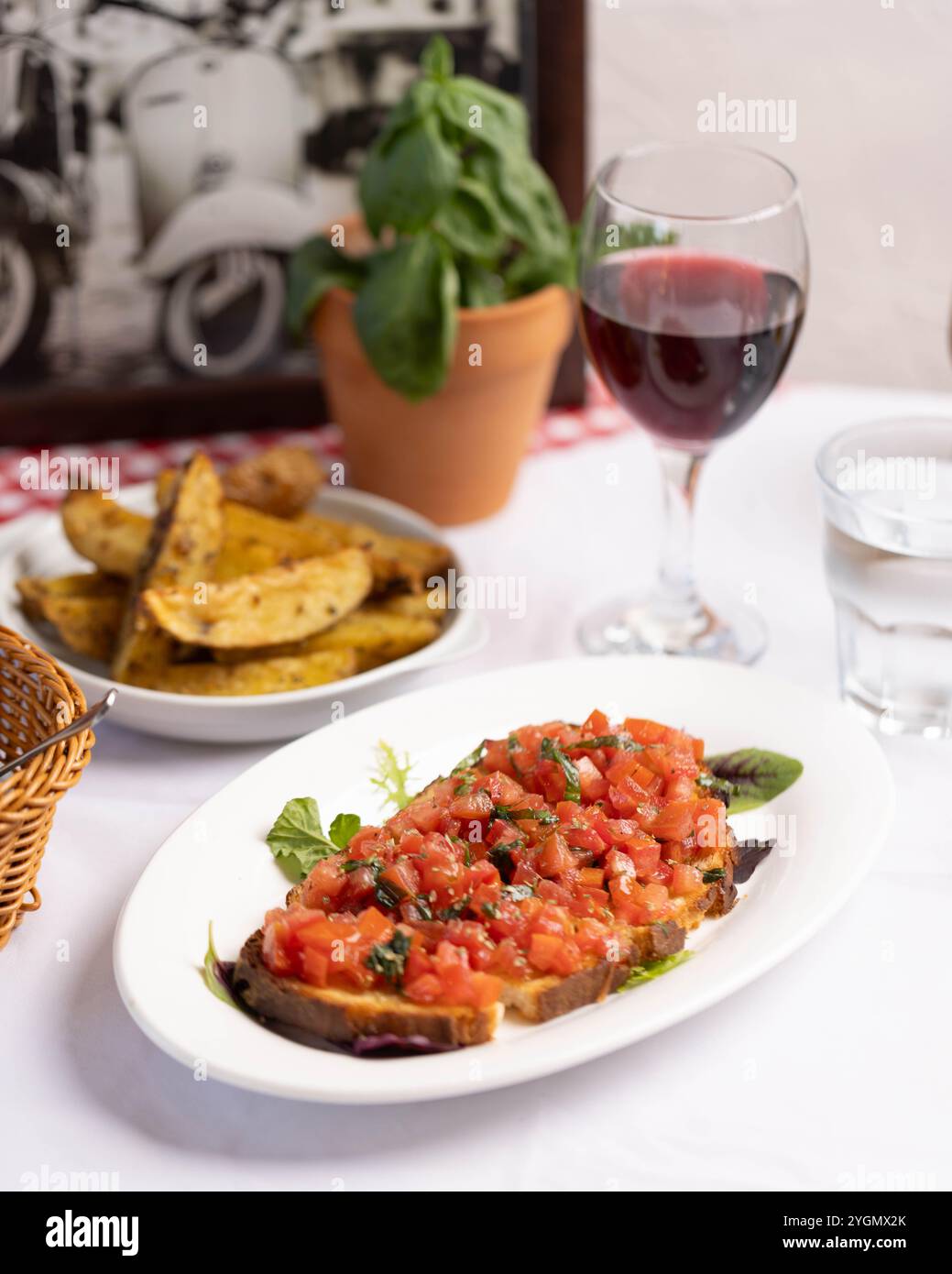 Klassische italienische Bruschetta mit frischen Tomaten, Basilikum und einem Hauch Olivenöl auf geröstetem Brot – eine einfache, geschmackvolle Vorspeise. Stockfoto