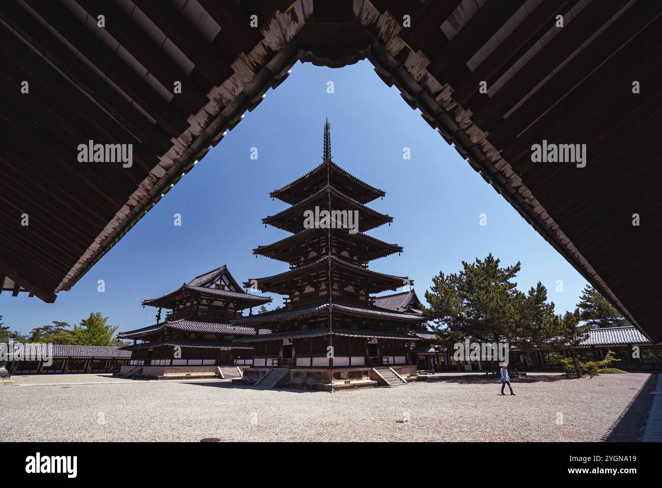 Ein Mann läuft vor der fünfstöckigen Pagode des buddhistischen Tempels Horyuji in Nara. Der Tempel und die Pagode sind mehr als 1400 Jahre alt Stockfoto