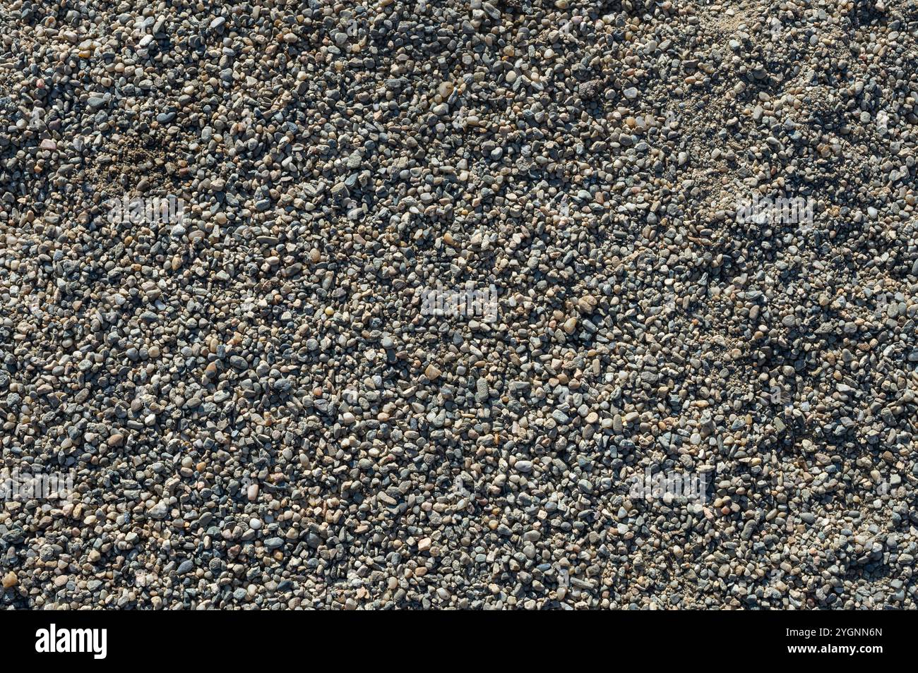 Hintergrund mit Textur von Kieselsteinen, kleiner Kiesrohstoff bei der Betonherstellung Stockfoto