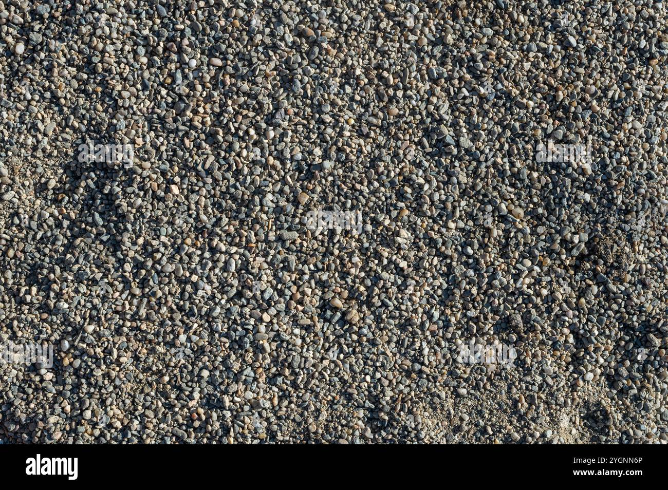 Hintergrund mit Textur von Kieselsteinen, kleiner Kiesrohstoff bei der Betonherstellung Stockfoto