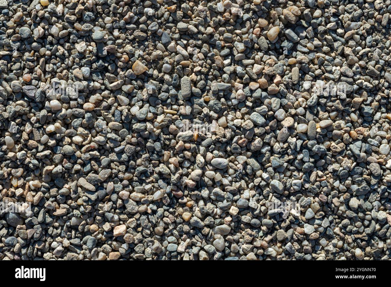 Hintergrund mit Textur von Kieselsteinen, kleiner Kiesrohstoff bei der Betonherstellung Stockfoto