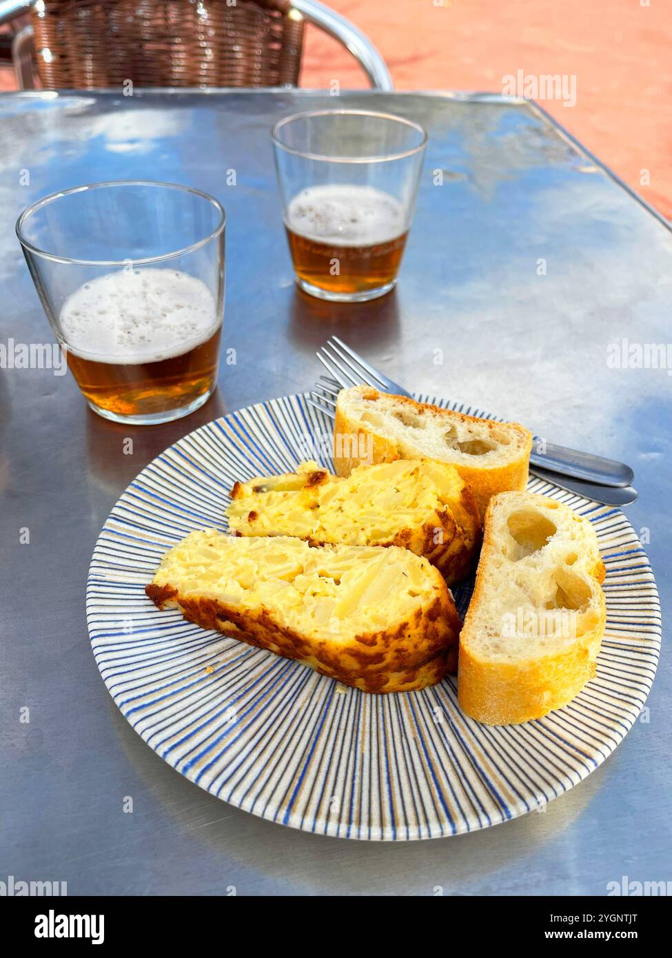 Spanisches Omelett-Pachcho mit zwei Gläsern Bier auf einer Terrasse. Spanien. - Smartphone-aufgenommenes Stockfoto