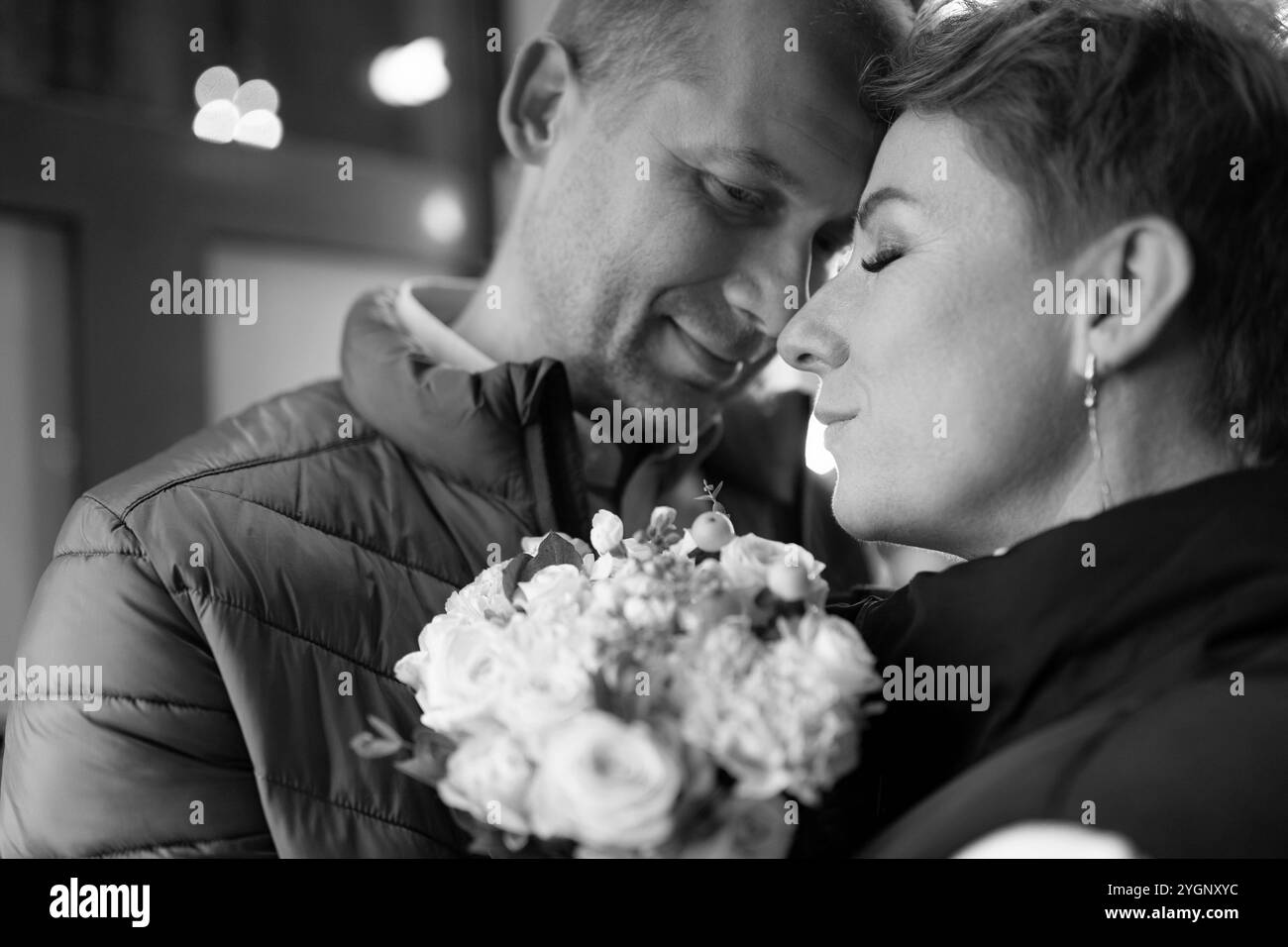 Ein Paar spaziert nachts durch die Stadt und teilt einen zärtlichen Moment Stockfoto