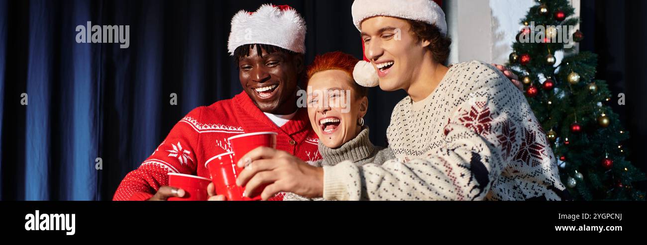 Kollegen feiern gemeinsam Weihnachten, indem sie im Büro Lachen und festliche Drinks teilen. Stockfoto