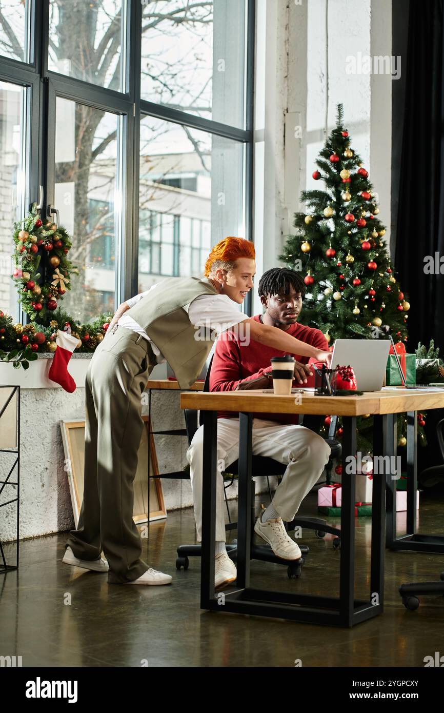 Festliche Kollegen machen fröhliche Urlaubsvorbereitungen an ihrem Arbeitsplatz Stockfoto