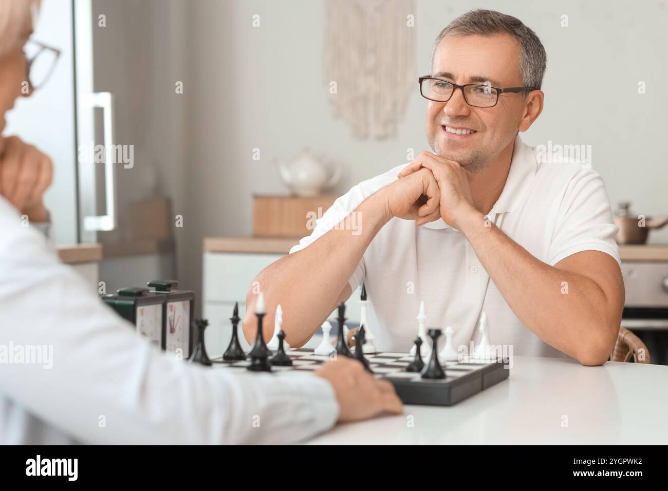 Seniorenpaar, das zu Hause gemeinsam Schach spielt Stockfoto