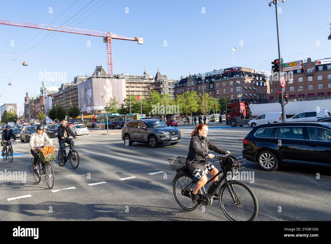 Männer und Frauen, die mit ihren Fahrrädern durch das Stadtzentrum von Kopenhagen fahren, auf einem speziellen Radweg neben Kraftfahrzeugen Stockfoto