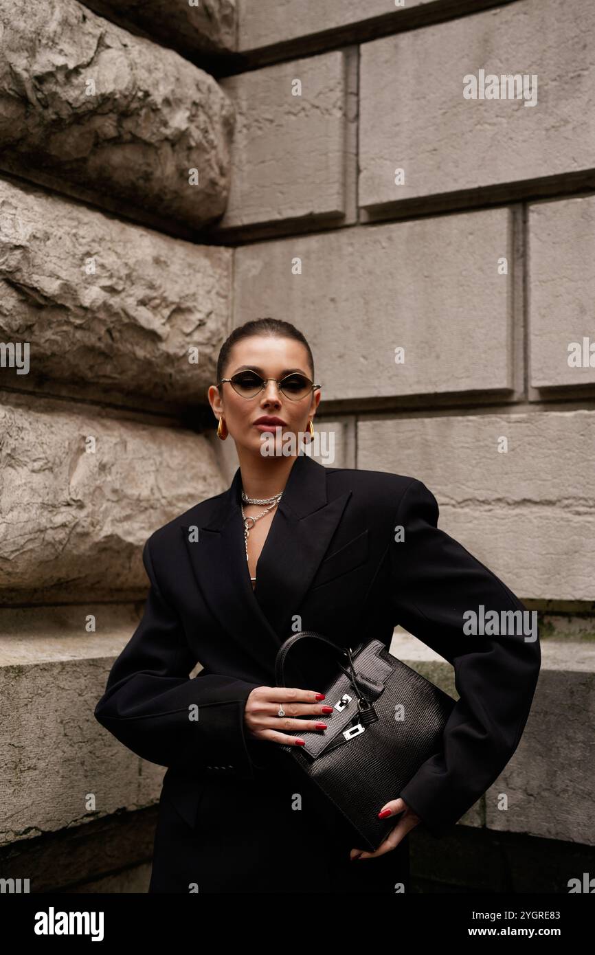 Polina Erofeeva mit komplett schwarzem Outfit kombiniert mit einem übergroßen Blazer, Minirock, Stiefeln und einem birkin auf der Hermès Show in der Pariser Fashion Week SS25 Stockfoto