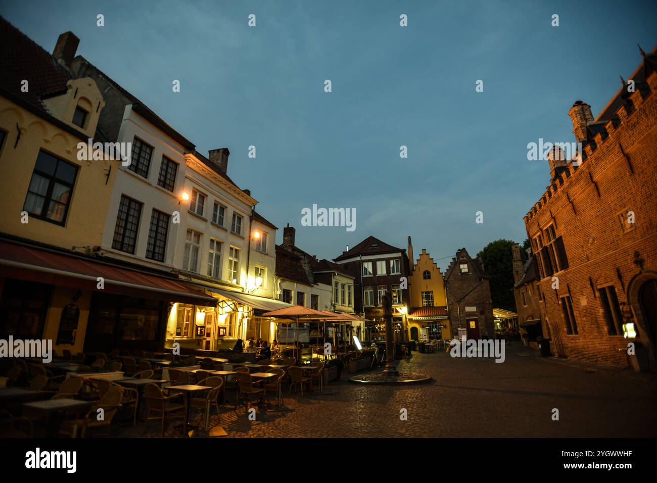 Historische Café-Terrassen in Huidenvettersplein in der Abenddämmerung - Brügge, Belgien Stockfoto