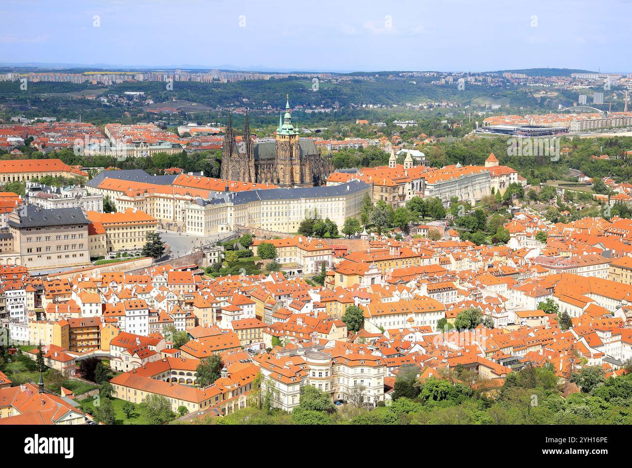 Panoramablick aus der Vogelperspektive auf die Prager Burg und die kleineren Bürgerhäuser mit roten Dächern in Prag, Tschechische Republik Stockfoto