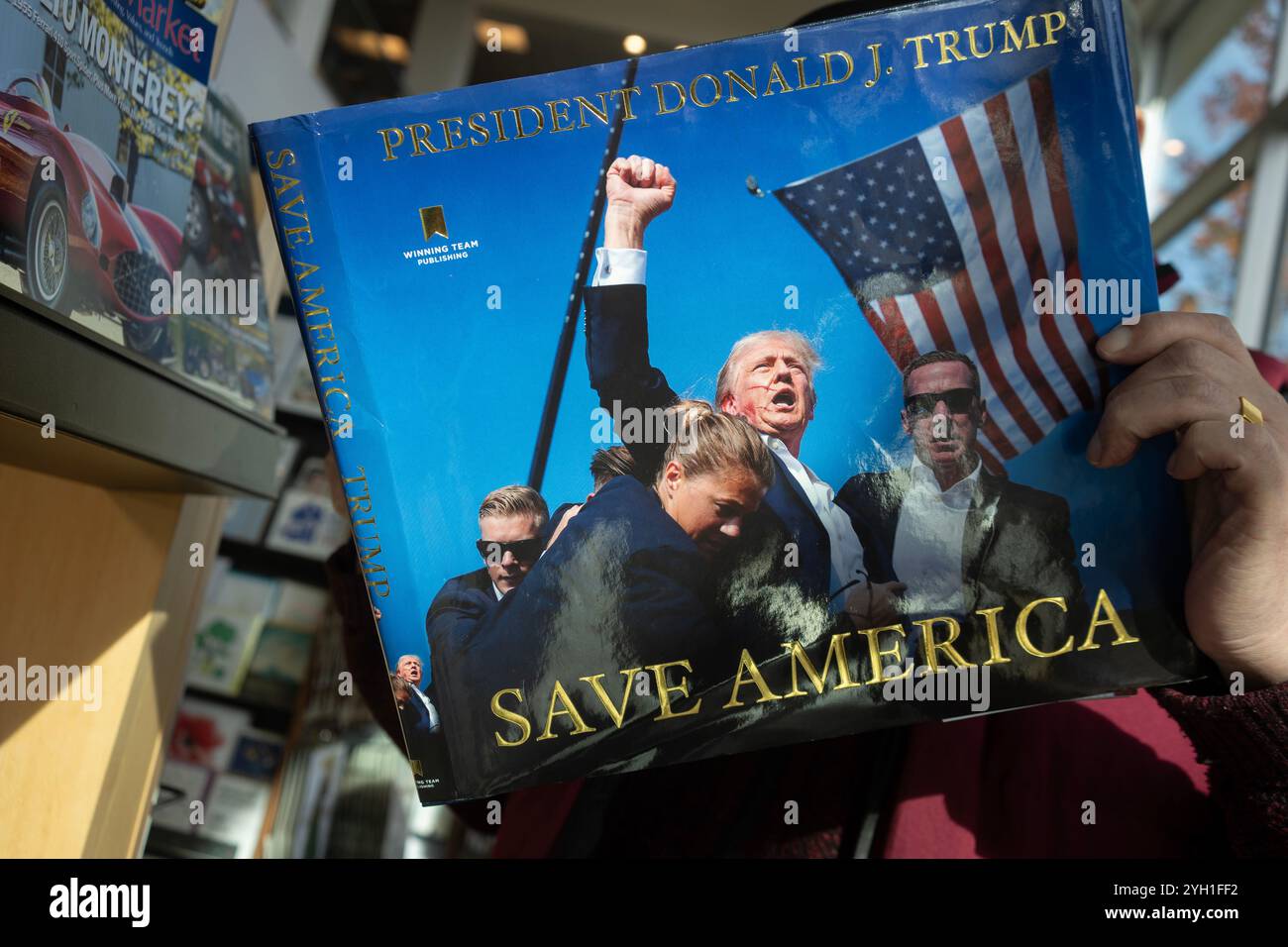 Ein Kunde durchstöbert das Buch „Save America“ von Donald J. Trump, das einen Blick auf seine erste Amtszeit und eine Vision für seine nächste Amtszeit in einem Buchladen in... Stockfoto