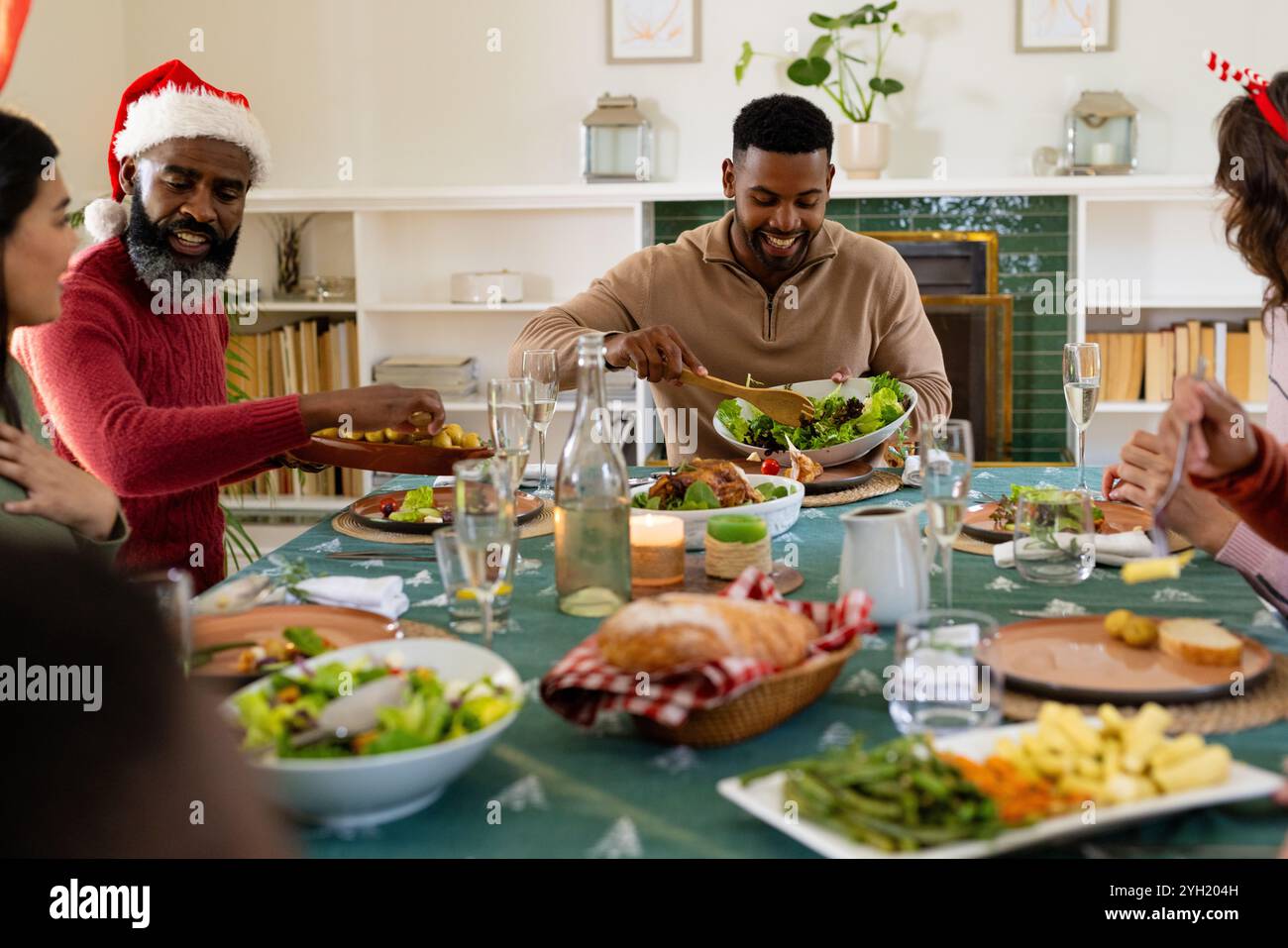 Familie mit mehreren Rassen teilt köstliches Essen während festlichem weihnachtsessen zusammen, zu Hause Stockfoto