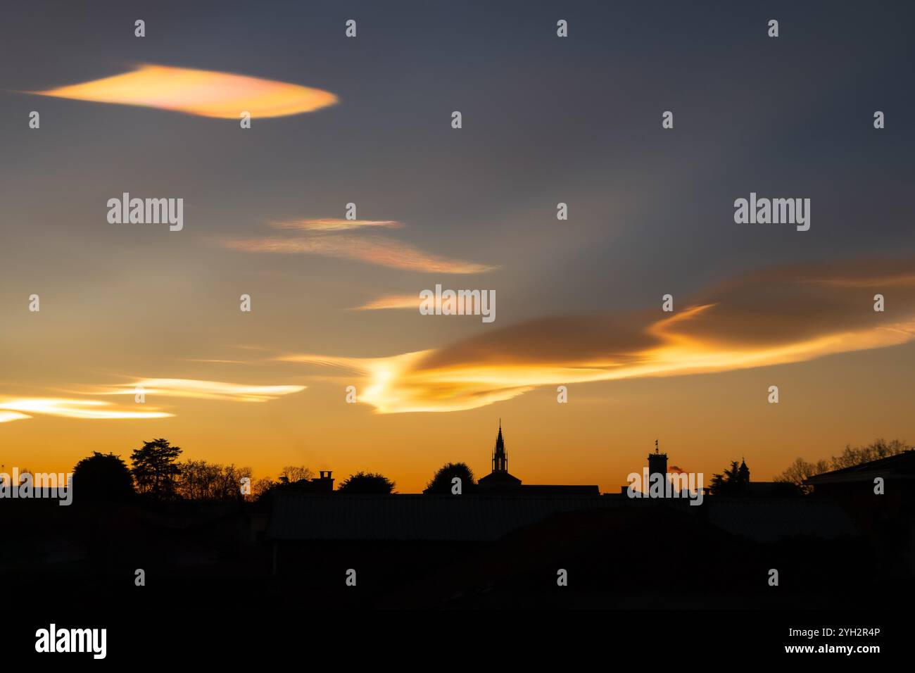 Schillernde Wolken während eines wunderschönen Wintersonnenverkehrs über der Stadt. Stockfoto