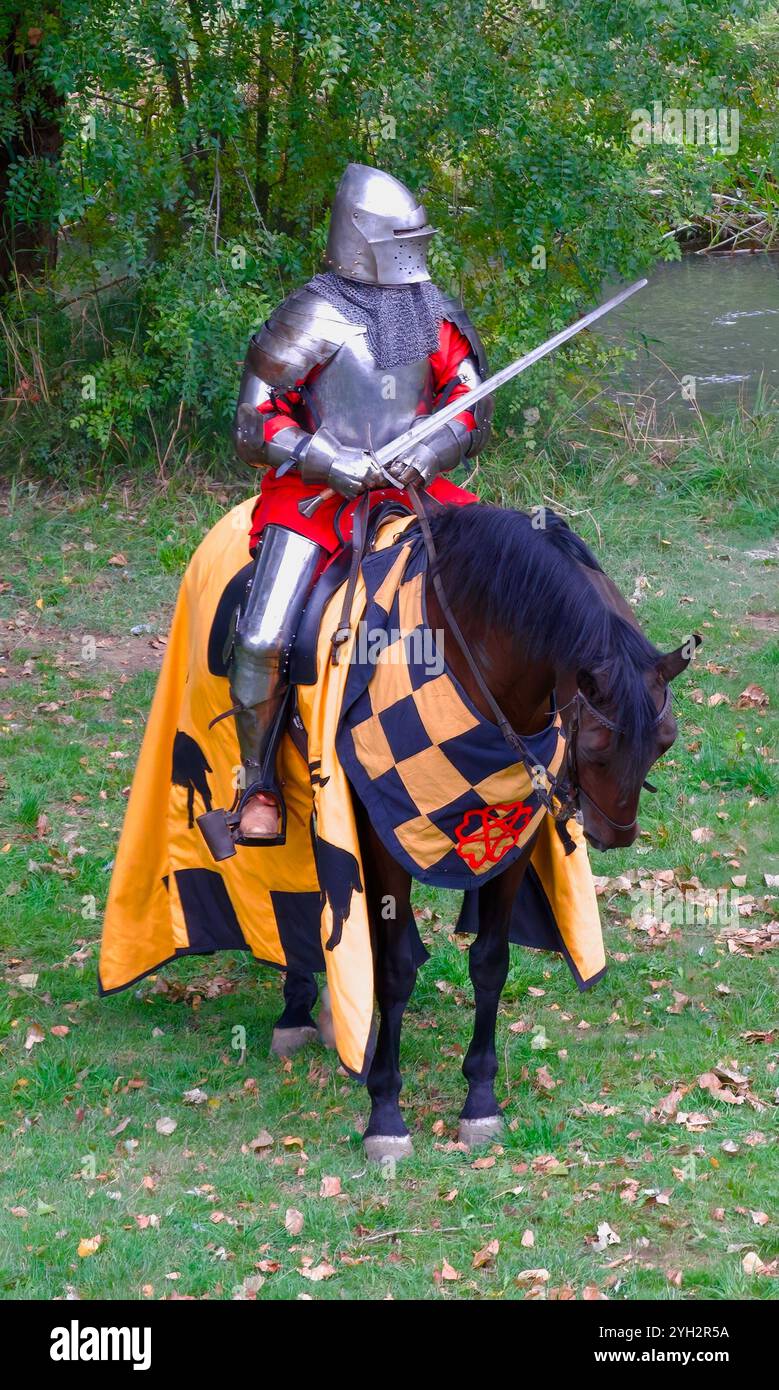 Mann in Rüstung reitet auf einem kapariszierten Pferd während einer historischen Nachstellung eines mittelalterlichen Turniers El Cid Fiestas Burgos Castile & Leon Spanien Stockfoto