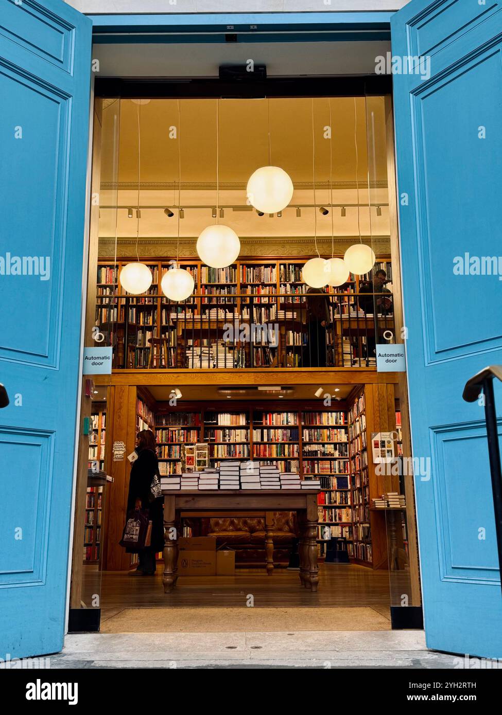Ein einladender Blick auf eine gemütliche Buchhandlung mit hohen Regalen voller Bücher, die die Leser zum Erkunden einladen. - Smartphone-aufgenommenes Stockfoto