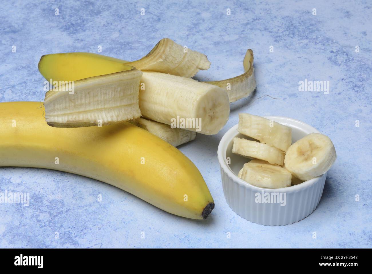 Geöffnete Bananen und Bananenscheiben in Schalen Stockfoto