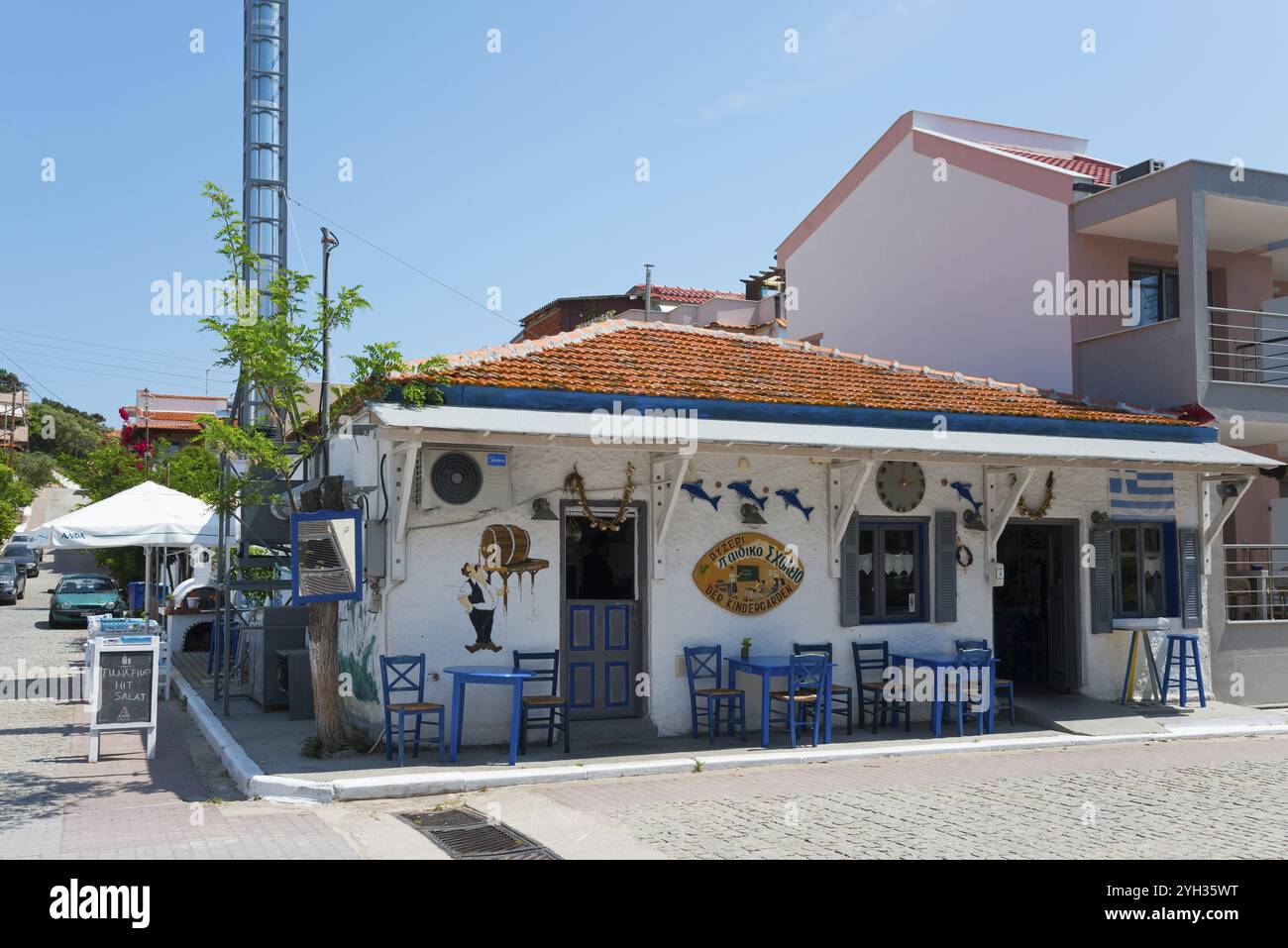 Rustikale Taverne an der Ecke mit weißer Fassade, blauen Stühlen und dekorativen Elementen, Sarti, Sithonia, Chalkidiki, Chalkidiki, Zentralmakedonien Stockfoto