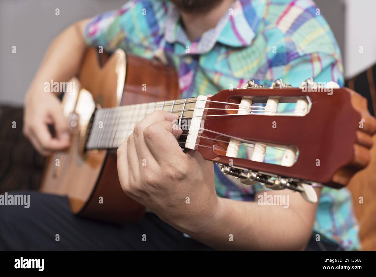 Bärtiger Hipster-Mann, der Akustikgitarre spielt. Nahaufnahme selektiver Fokus auf Hand Stockfoto