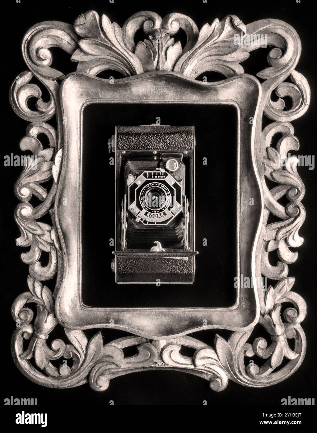 Vintage 1930er Jahre Kodak sechs-20-Rollen-Filmkamera achteckige Art Deco Faltkamera F8 Modell 0 mit Kodon-Verschluss im kunstvollen Goldrahmen als fotografische Kunst. Stockfoto