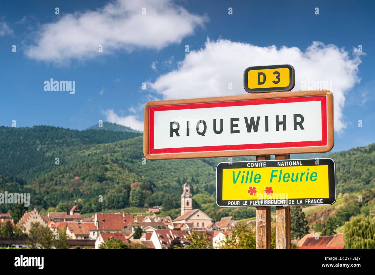 Riquewihr Straßenschild mit Dorf dahinter auf der D3 außerhalb des historischen mittelalterlichen attraktiven Weindorfes Riquewihr im Elsass Frankreich Stockfoto