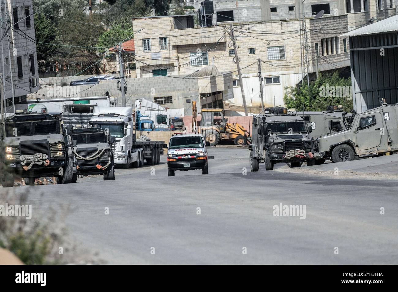 Jenin, Palästina. November 2024. Israelische Militärfahrzeuge umzingelten ein Haus, das von einem Palästinenser bewohnt wurde, und sperrten die Straße während eines Überfalls, um einen Palästinenser im Dorf Aqaba, südlich der Stadt Dschenin, im nördlichen Westjordanland, zu verhaften. Stundenlang brachen Zusammenstöße zwischen Palästinensern und israelischen Truppen aus, die zum Tod eines Palästinensers führten, dessen Leiche von der Armee festgenommen wurde, und zur Verletzung eines anderen bei einer Militäroperation der israelischen Streitkräfte. (Foto: Nasser Ishtayeh/SOPA Images/SIPA USA) Credit: SIPA USA/Alamy Live News Stockfoto