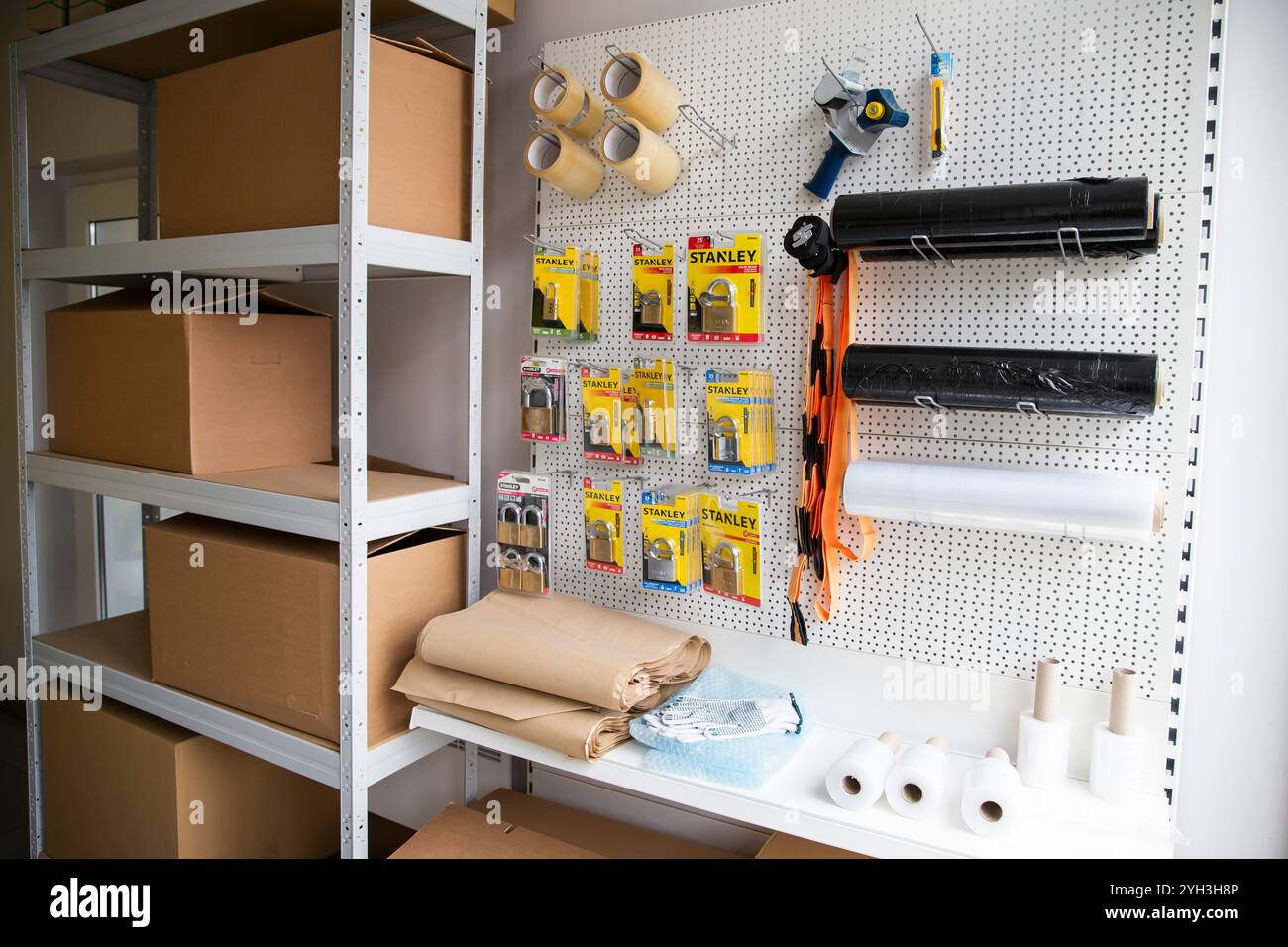 Organisierter Lagerbereich mit Boxen, Stanley Vorhängeschlössern, Verpackungsmaterialien und Werkzeugen. Stockfoto