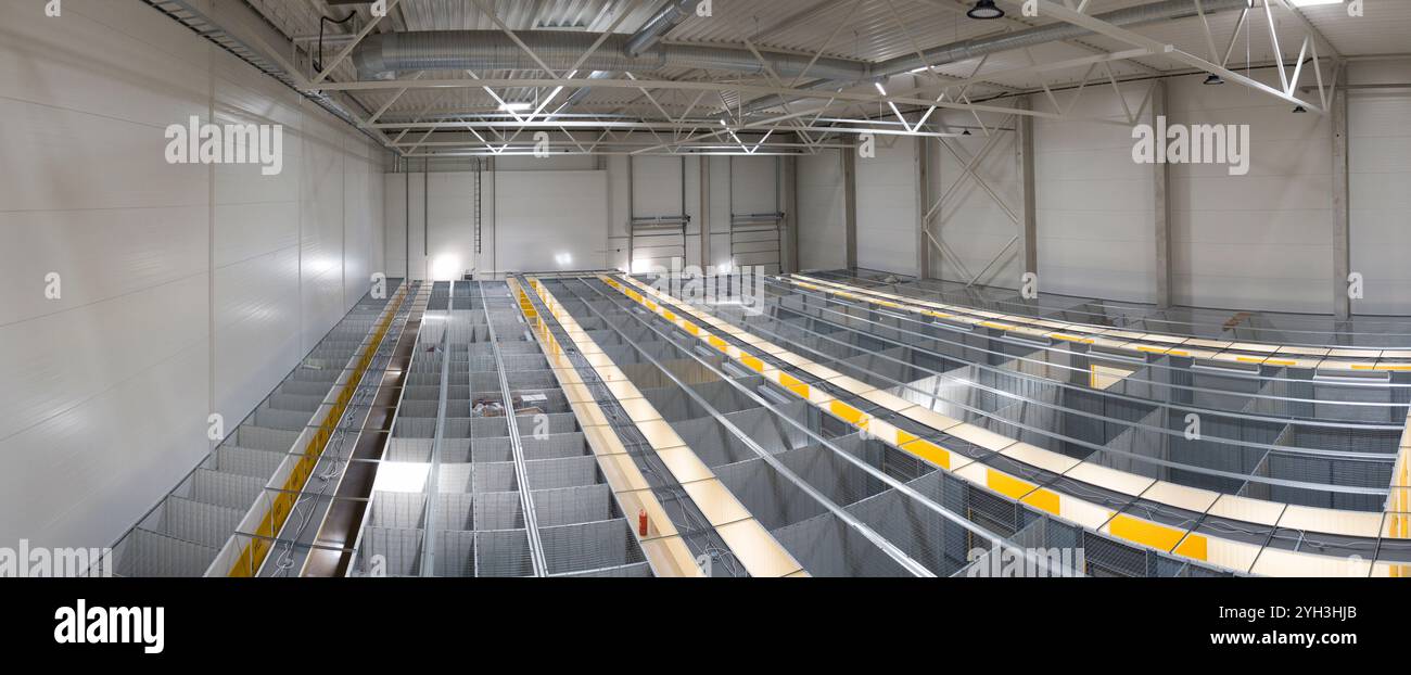 Geräumiges Lagerinnenlager mit organisiertem Metallregalsystem für effiziente Lagerung. Stockfoto