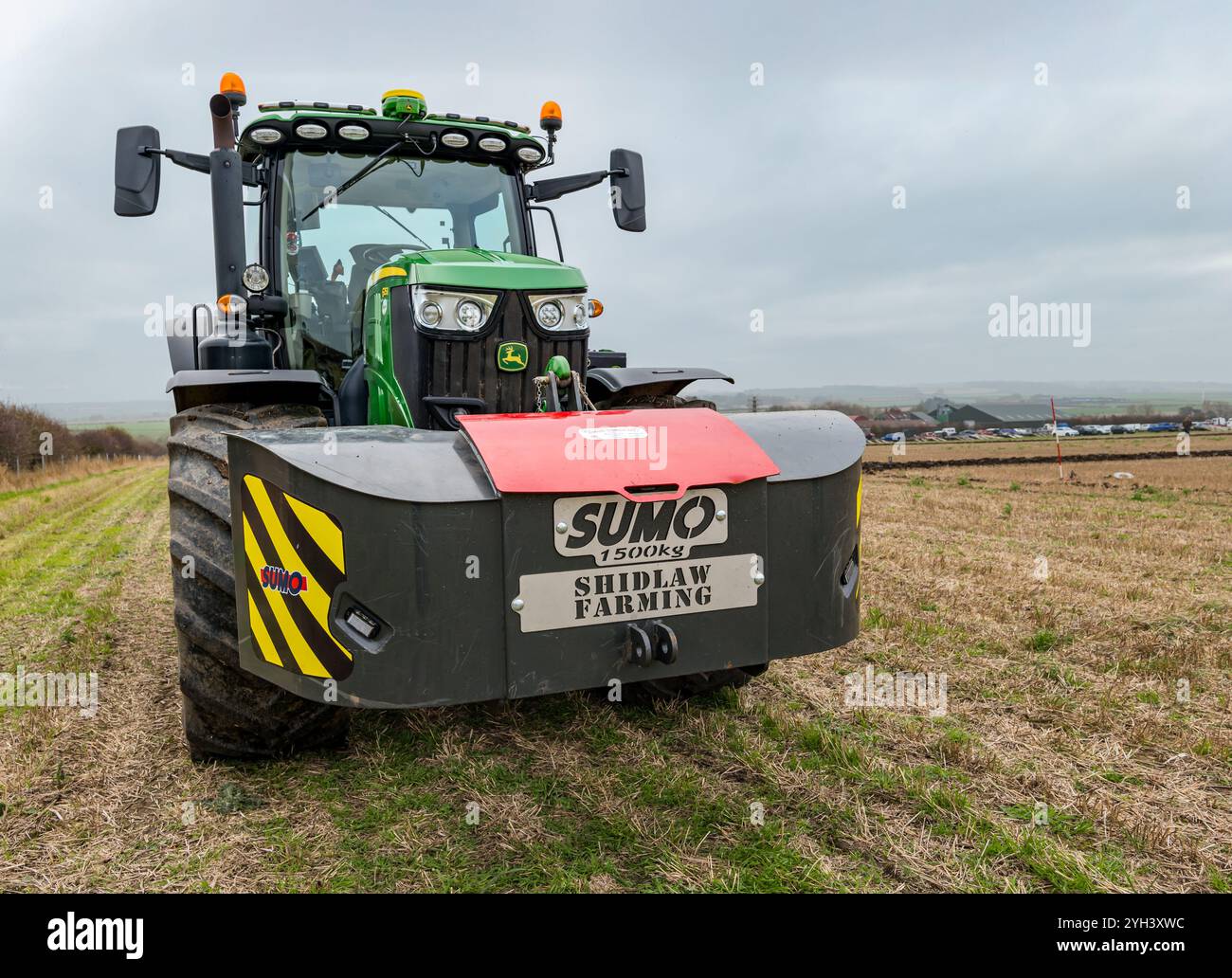 Großer John Deere-Traktor auf Stoppelfeld, East Lothian, Schottland, Großbritannien Stockfoto