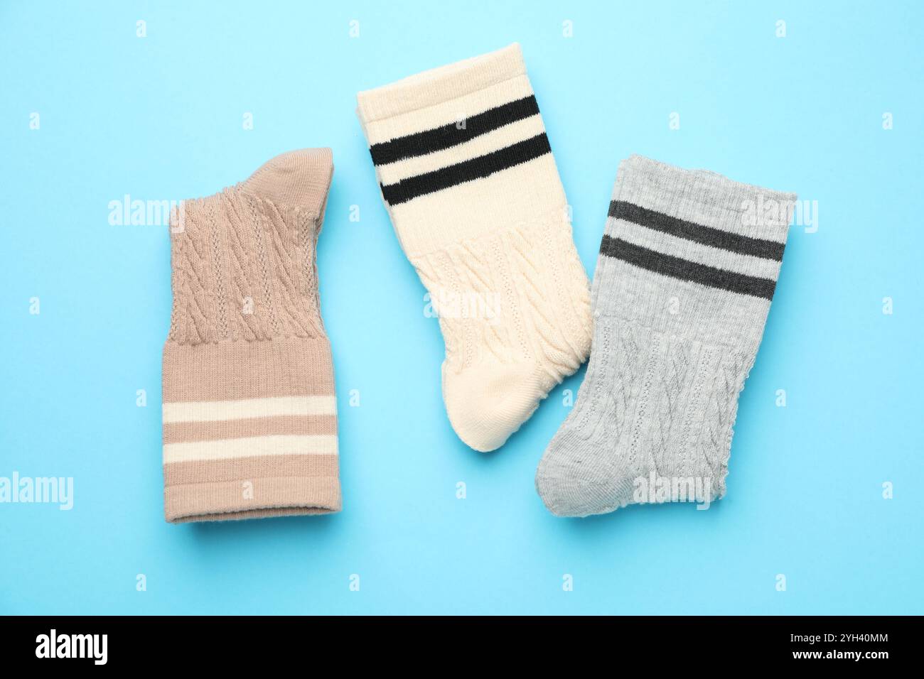 Verschiedene bequeme Socken auf hellblauem Hintergrund, flach geschnitten Stockfoto