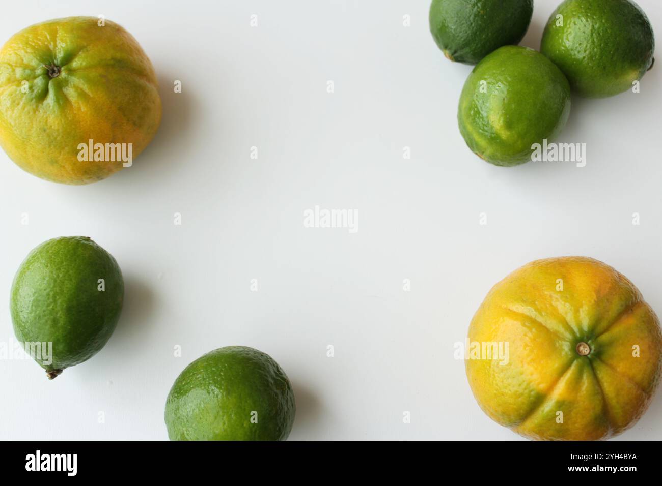 Organische Orangen und Limetten auf weißem Hintergrund, Kopierraum verfügbar. Gesunde frische tropische Früchte für mediterrane Ernährung und vegane gesunde Ernährung Stockfoto