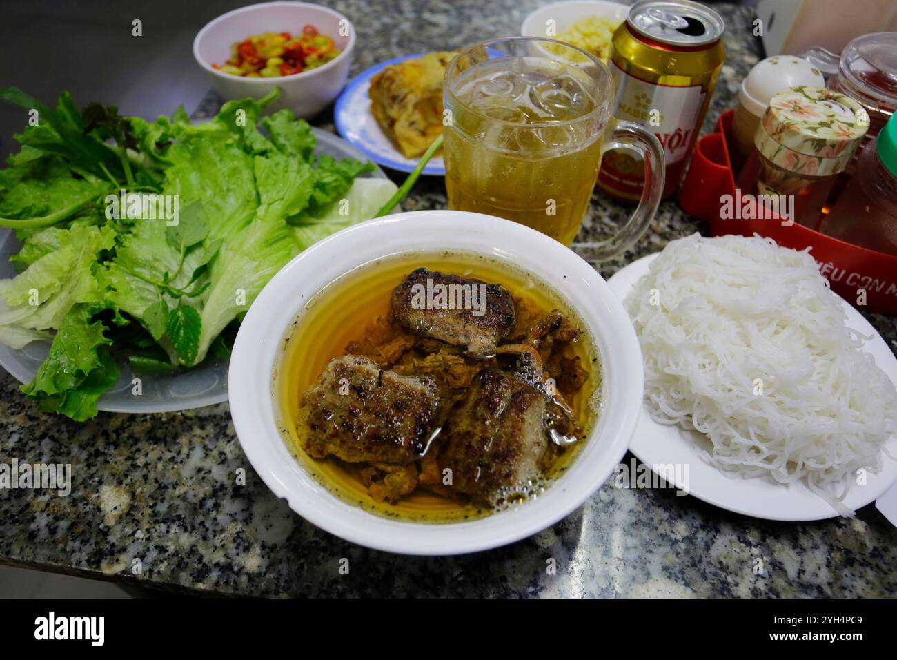 Hanoi, Vietnam - 8. Juli 2023: Bun Cha, ein vietnamesisches Gericht aus gegrilltem karamellisiertem Schweinefleisch, Nudeln und frischen Kräutern, wird im Bun Cha Huong Lien serviert. Stockfoto
