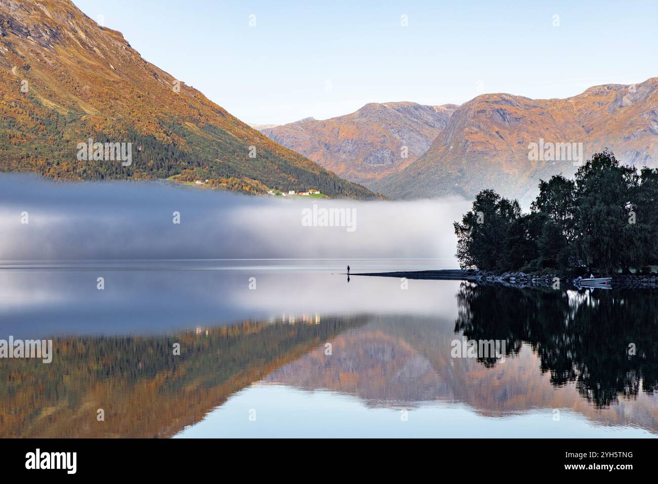 Der See Oppstrynsvatnet ist 230 Meter tief und einer der tiefsten Seen Norwegens in Stryn im County Vestland. Ein Mann im Silhouettenständer Stockfoto