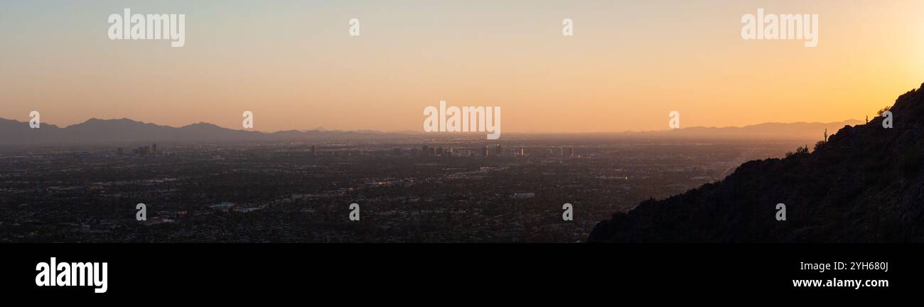 Downtown Phoenix und die umliegenden Vororte, beleuchtet mit Sonnenuntergang unter dem Camelback Mountain. Phoenix Mountains Preserve, Arizona Stockfoto