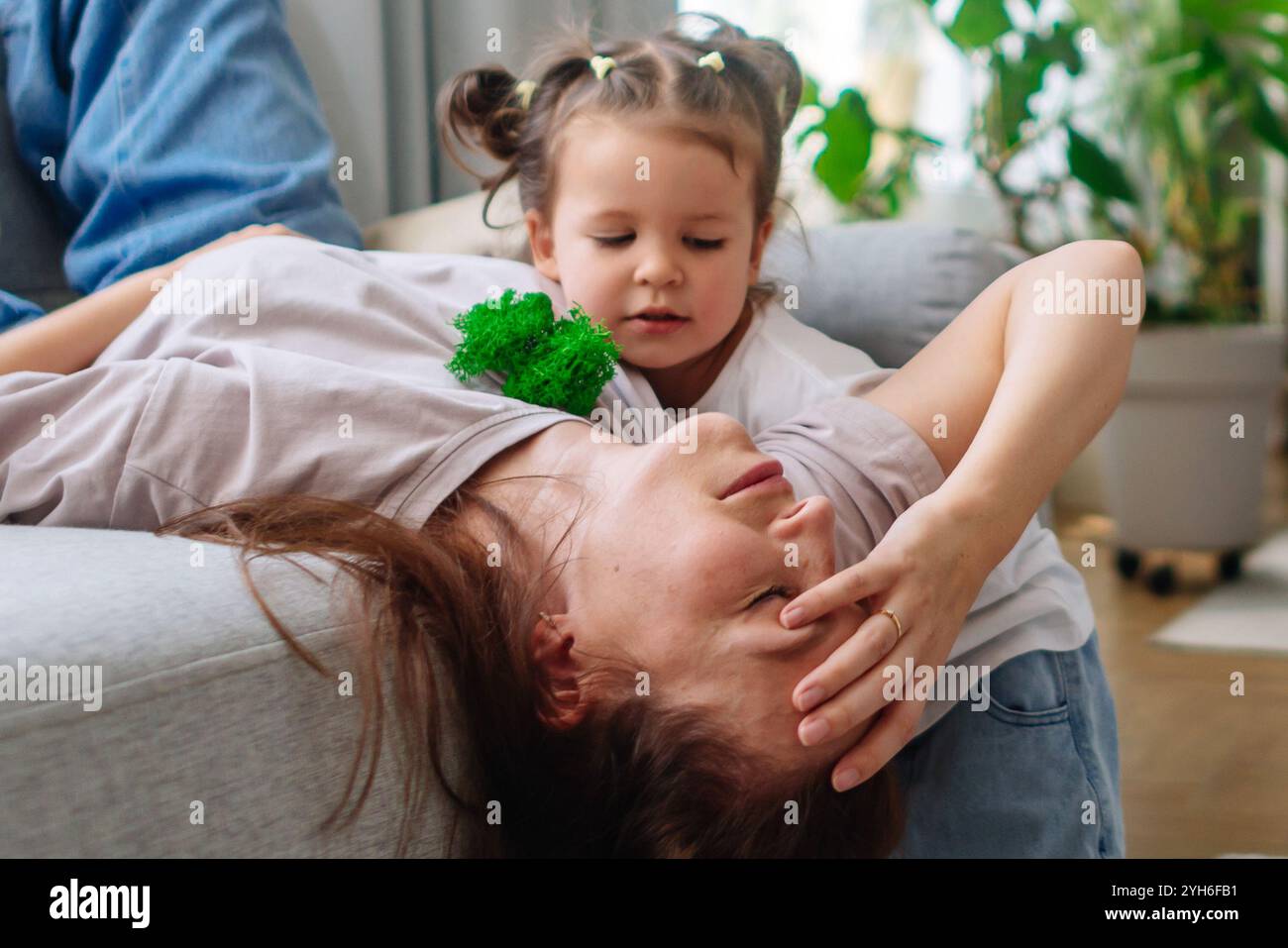 Mutter ist müde und das Kind verlangt Aufmerksamkeit Stockfoto