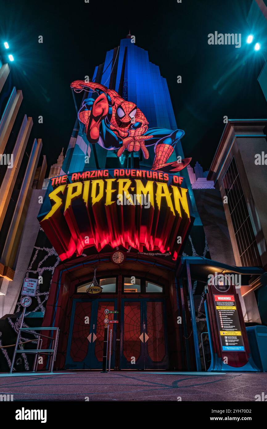 Ein dynamischer Blick auf den Eingang zur Attraktion „Amazing Adventures of Spider-man“, beleuchtet mit leuchtenden Lichtern und ikonischen Superheldenbildern. Stockfoto