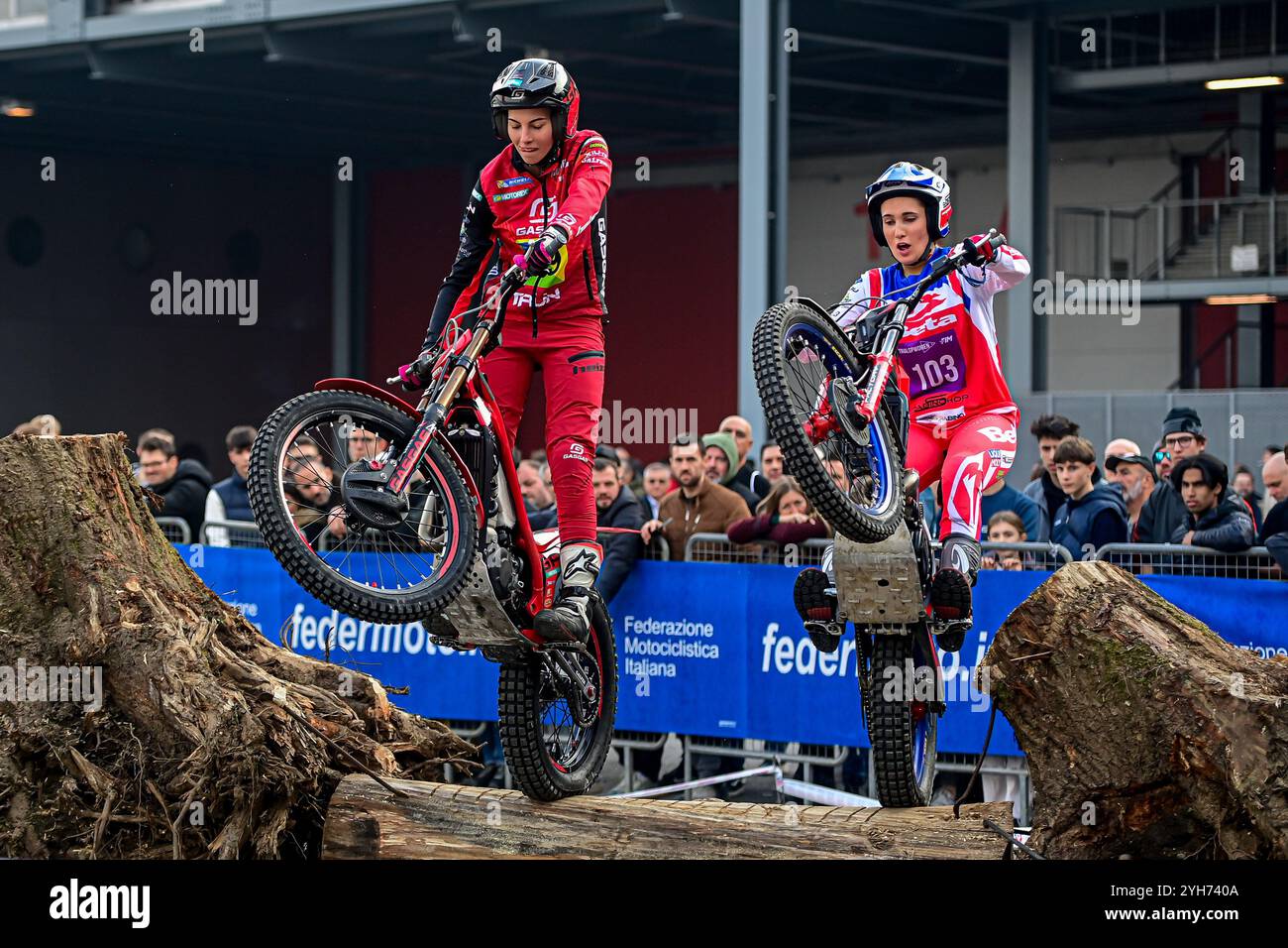 Die Fahrer treten mit ihren Motocross-Bikes auf hölzernen Hindernissen im Rahmen eines Probelaufs auf der EICMA Motorradmesse auf der Rho Fiera Milano in Mailand, Italien, an Stockfoto