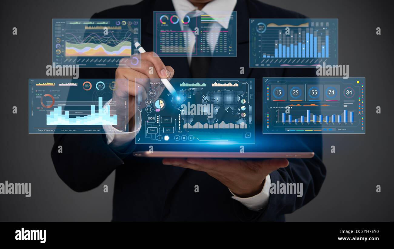 Geschäftsmann mit einem Tablet mit Eingabestift zur Analyse von Finanzdaten auf einem futuristischen digitalen Dashboard mit visuellen Analysen und Diagrammen Business Intelli Stockfoto